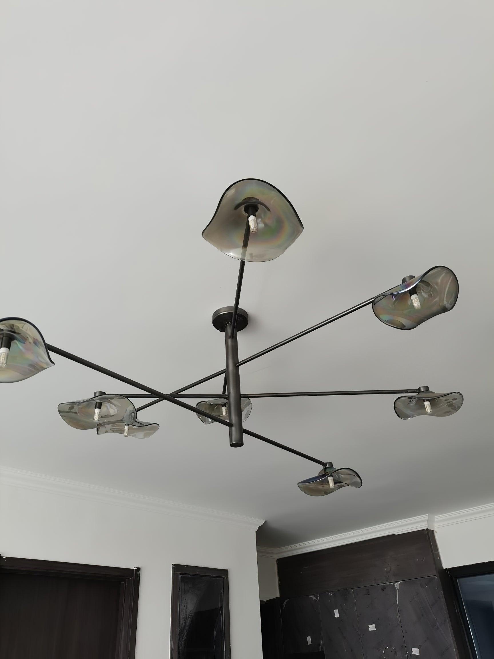 Black chandelier arms and glass shades viewed from below