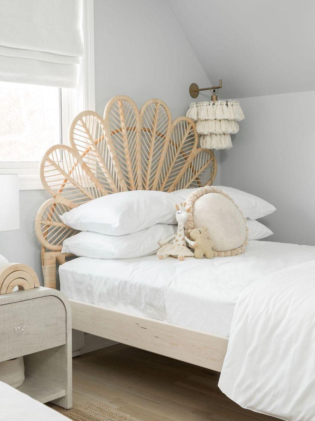 White tassel light beside a fan-shaped headboard