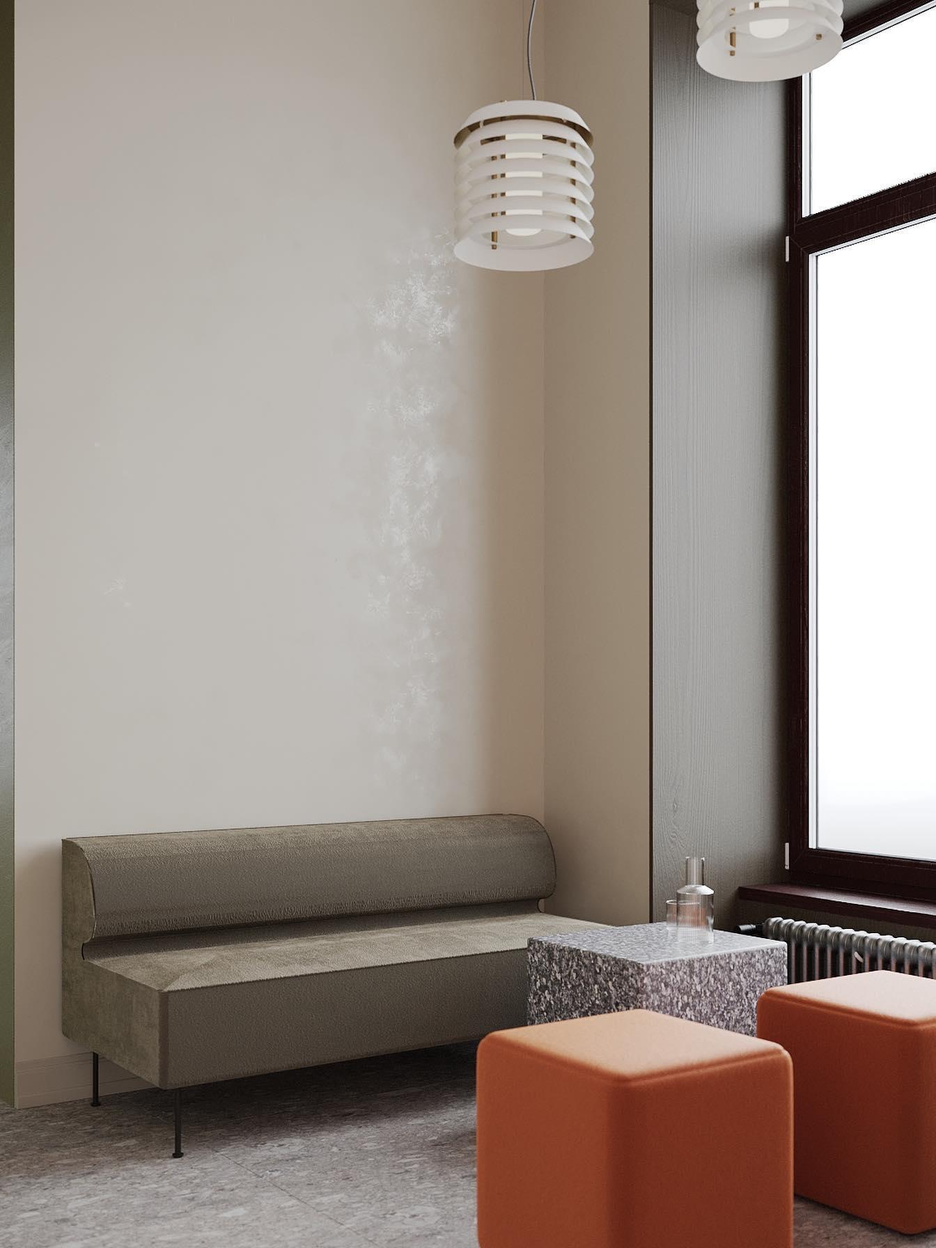 Small white stacked pendant near tall window above bench and orange cube seat