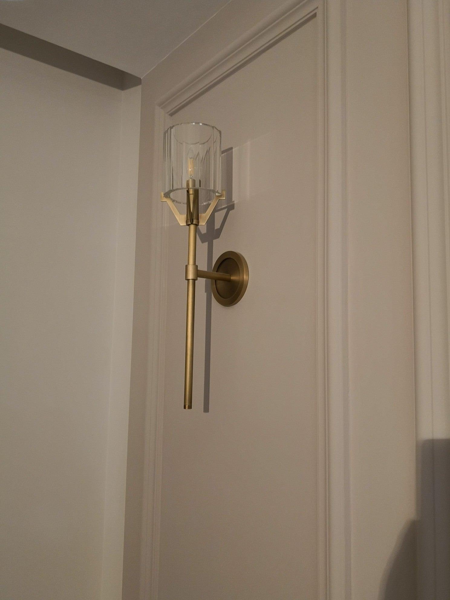 Tall Gold wall fixture shown in an interior alcove