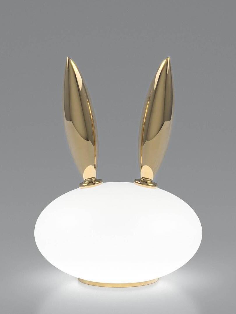 Isolated rabbit lamp with low oval white body, tall gold-tone ears and round base