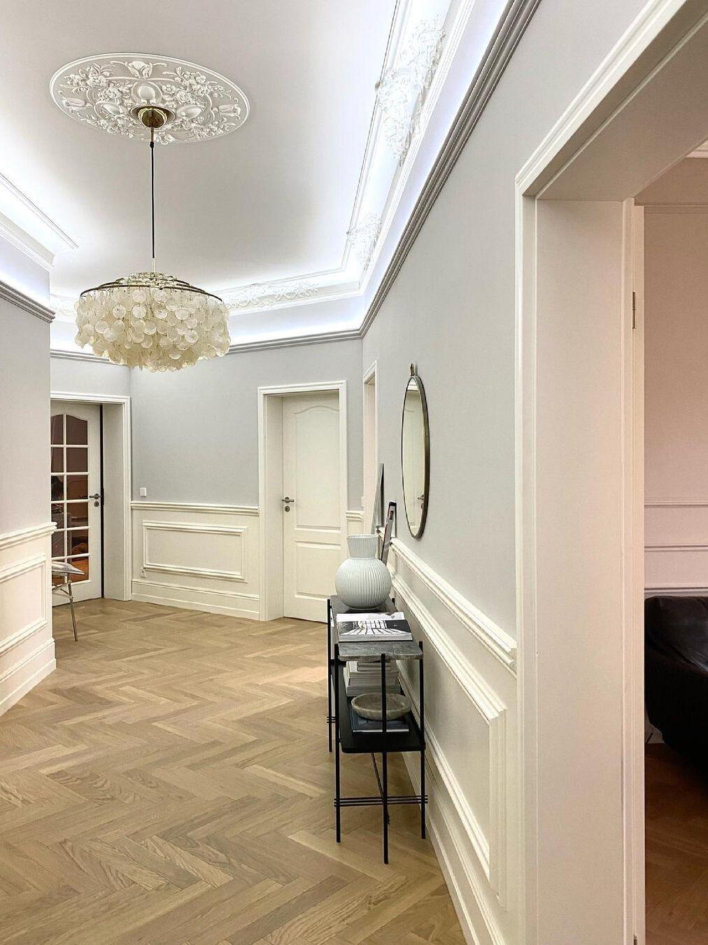 Round white shell fixture above a parquet floor