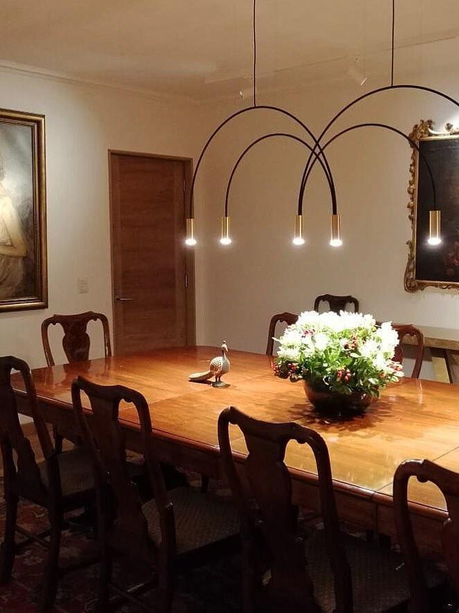 Arched pendant above a dining table with flowers