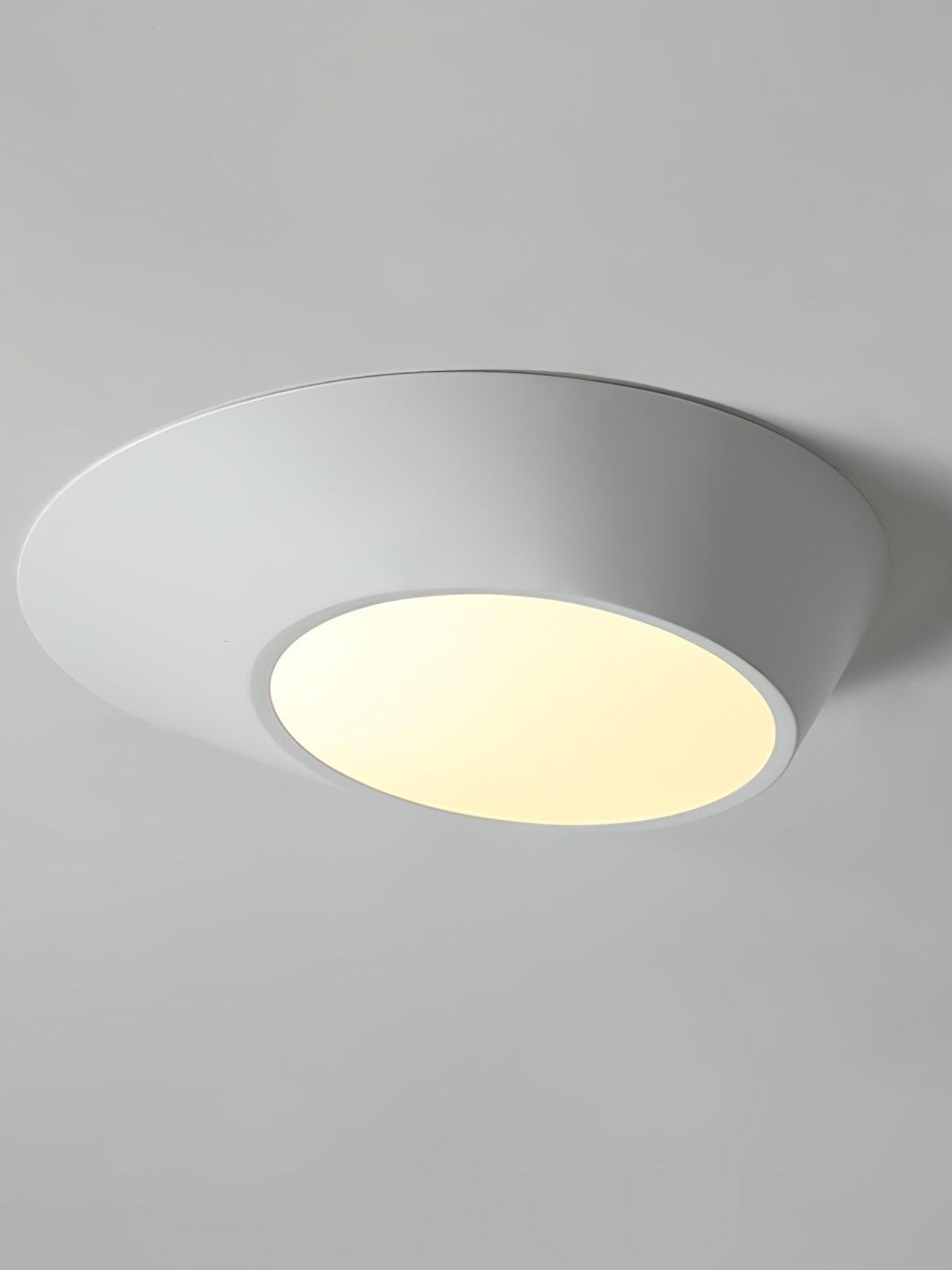 White angled ceiling light with a warm-looking glowing diffuser against a pale ceiling
