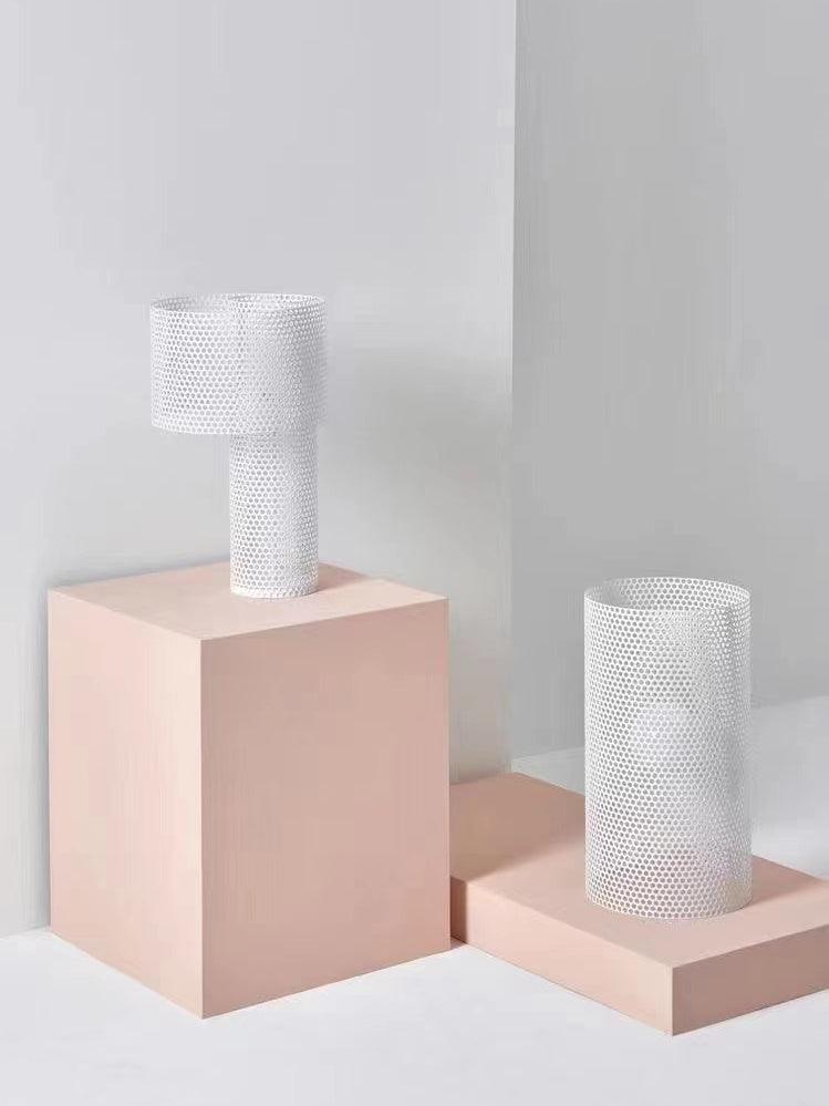 White Embrey table lamp and separate cylinder lamp on pink blocks
