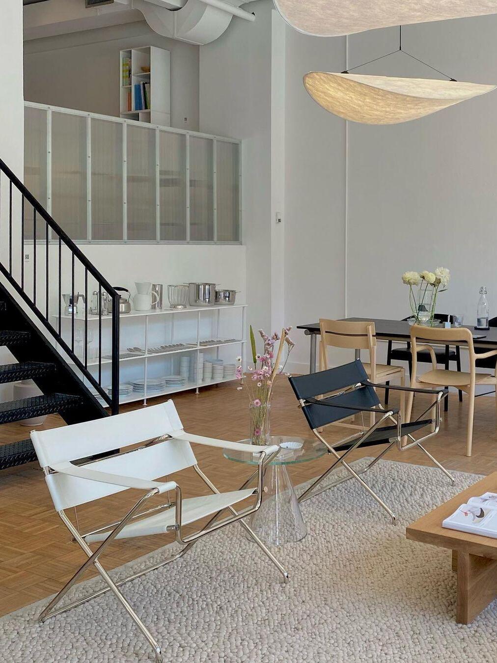 Sculptural pendant above a dining area near stairs
