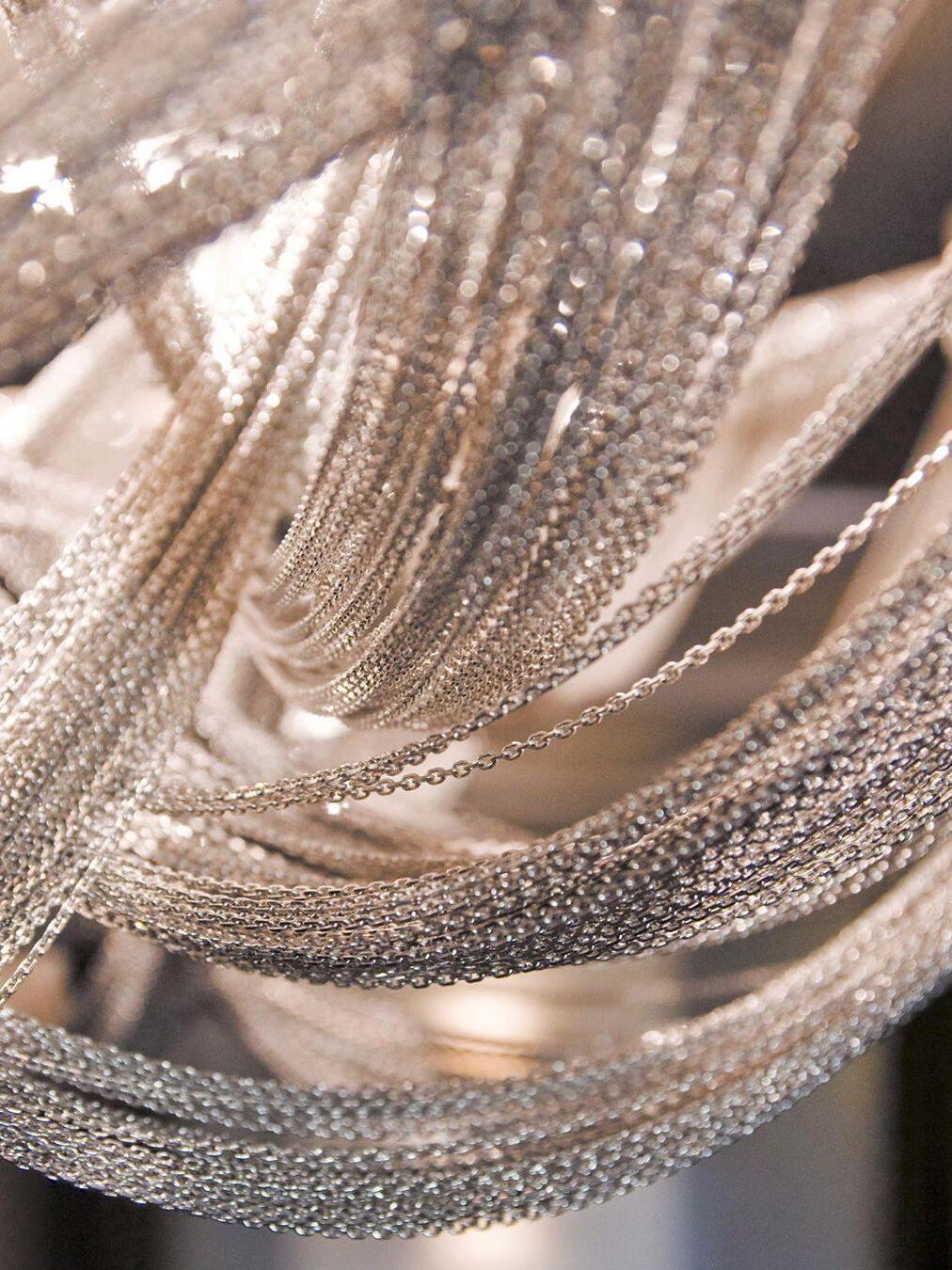 Warm-lit close view of gold-tone metal chain loops