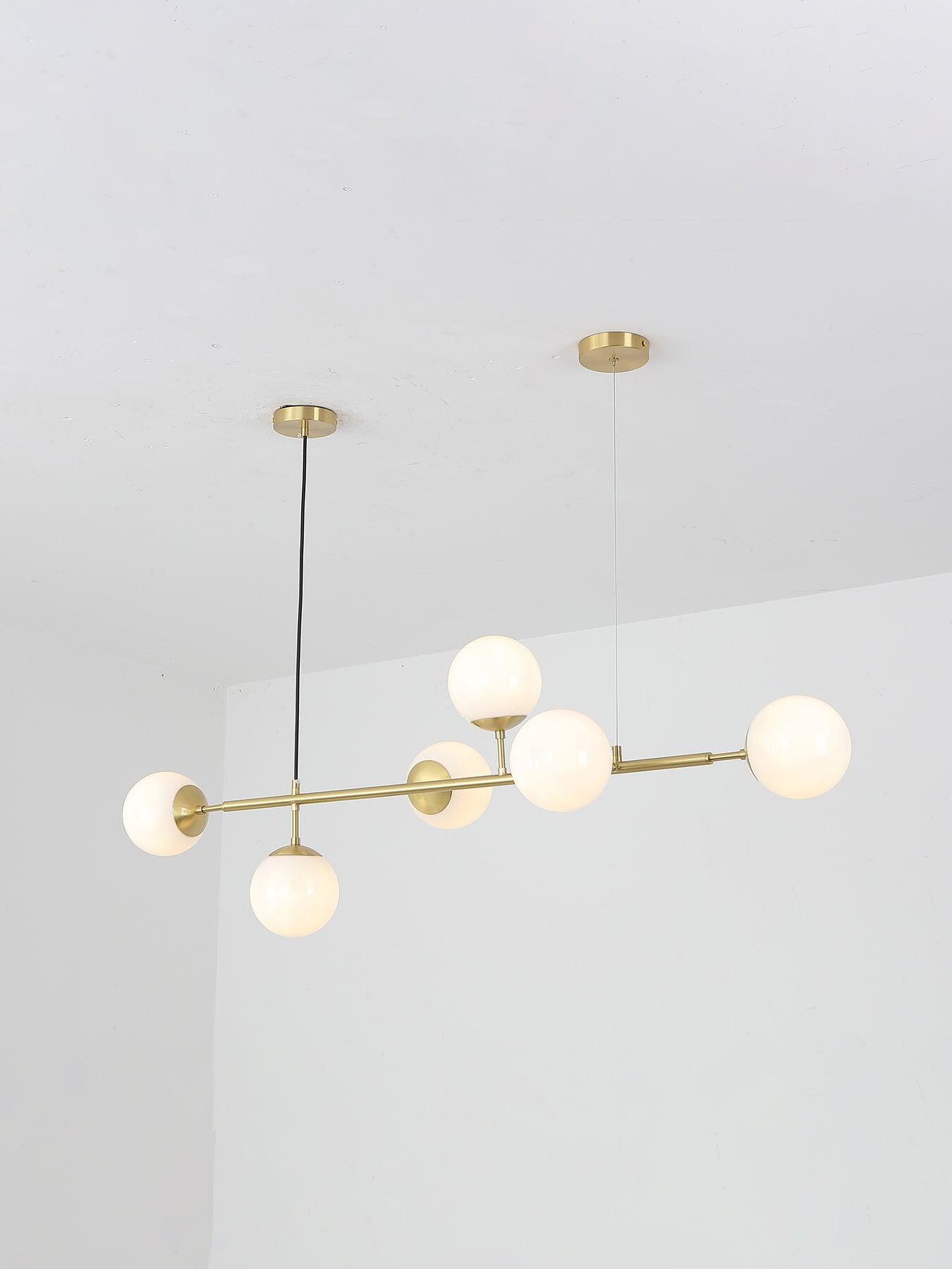 Illuminated white globes on a brass-coloured bar