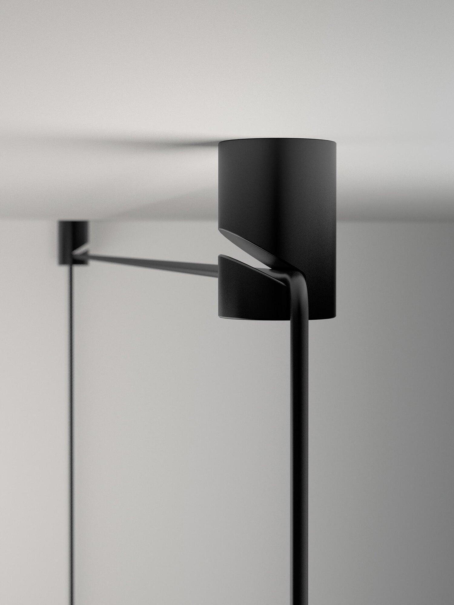 Close-up of a black ceiling cable holder with a side slot and routed cable