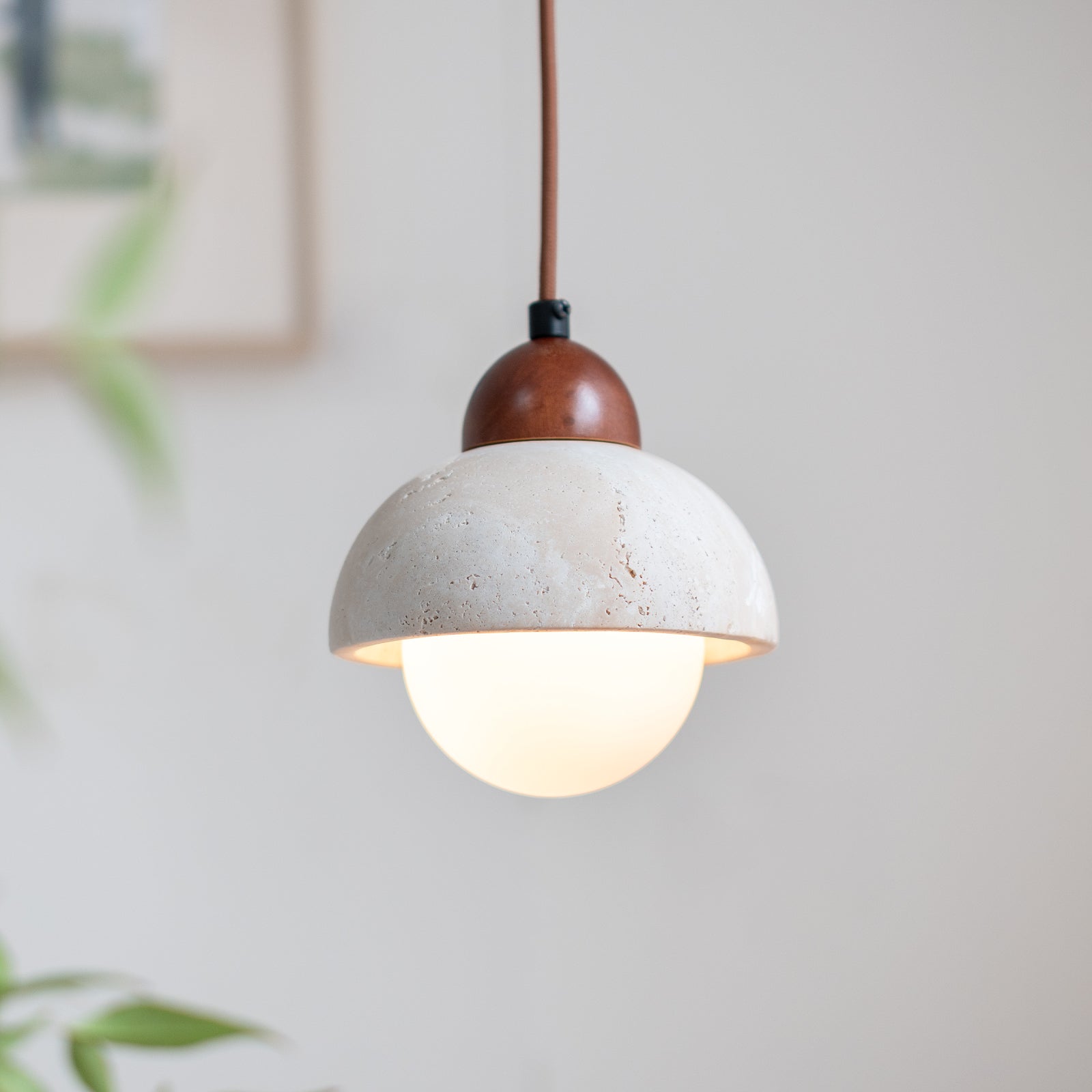 Illuminated white globe beneath a travertine dome shade