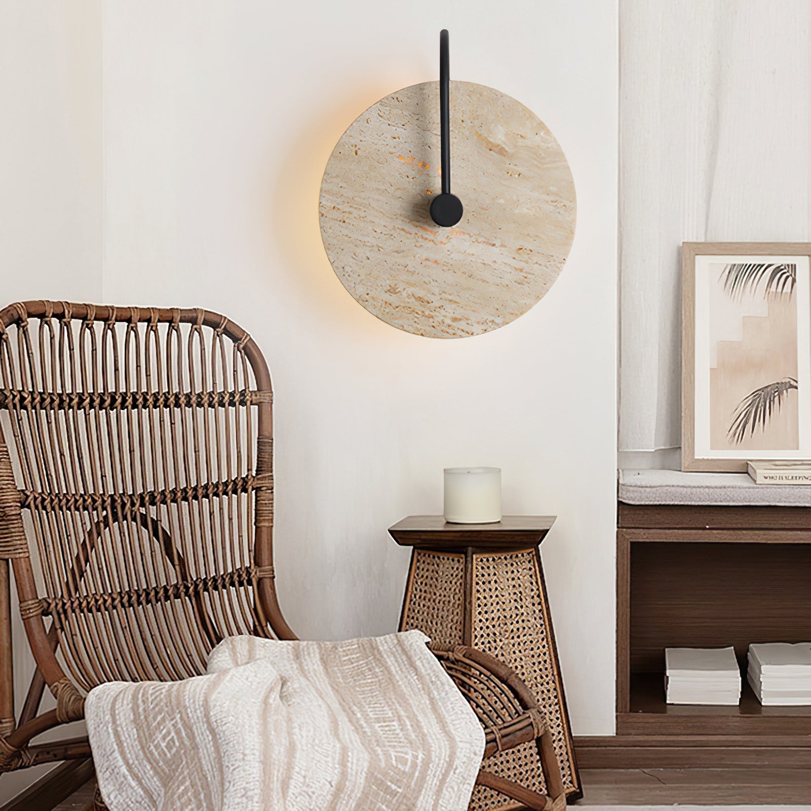 Travertine wall lamp with black arm beside a woven chair