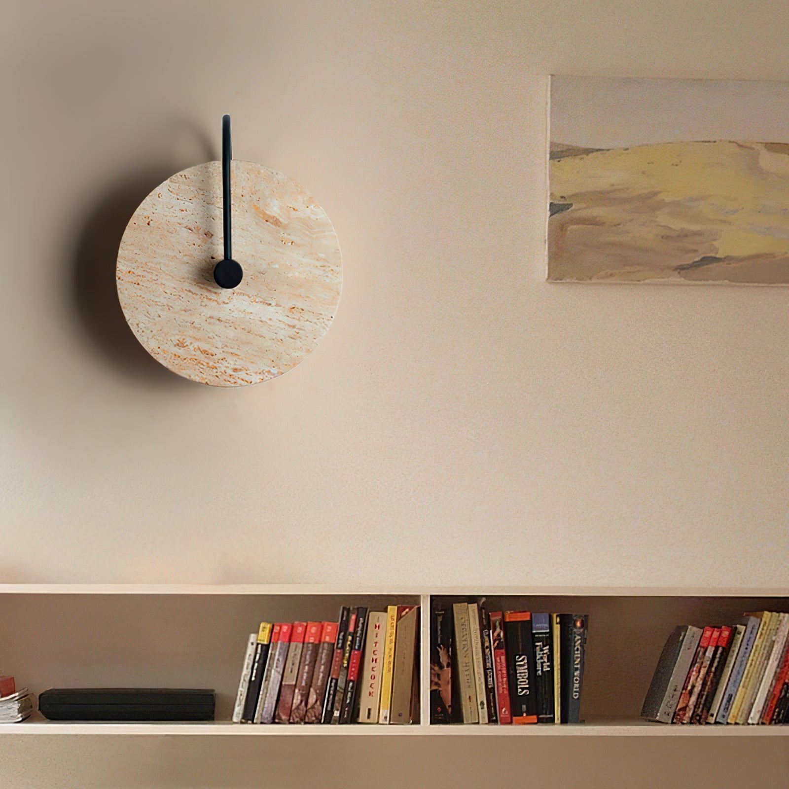 Unlit round stone wall lamp above a bookshelf