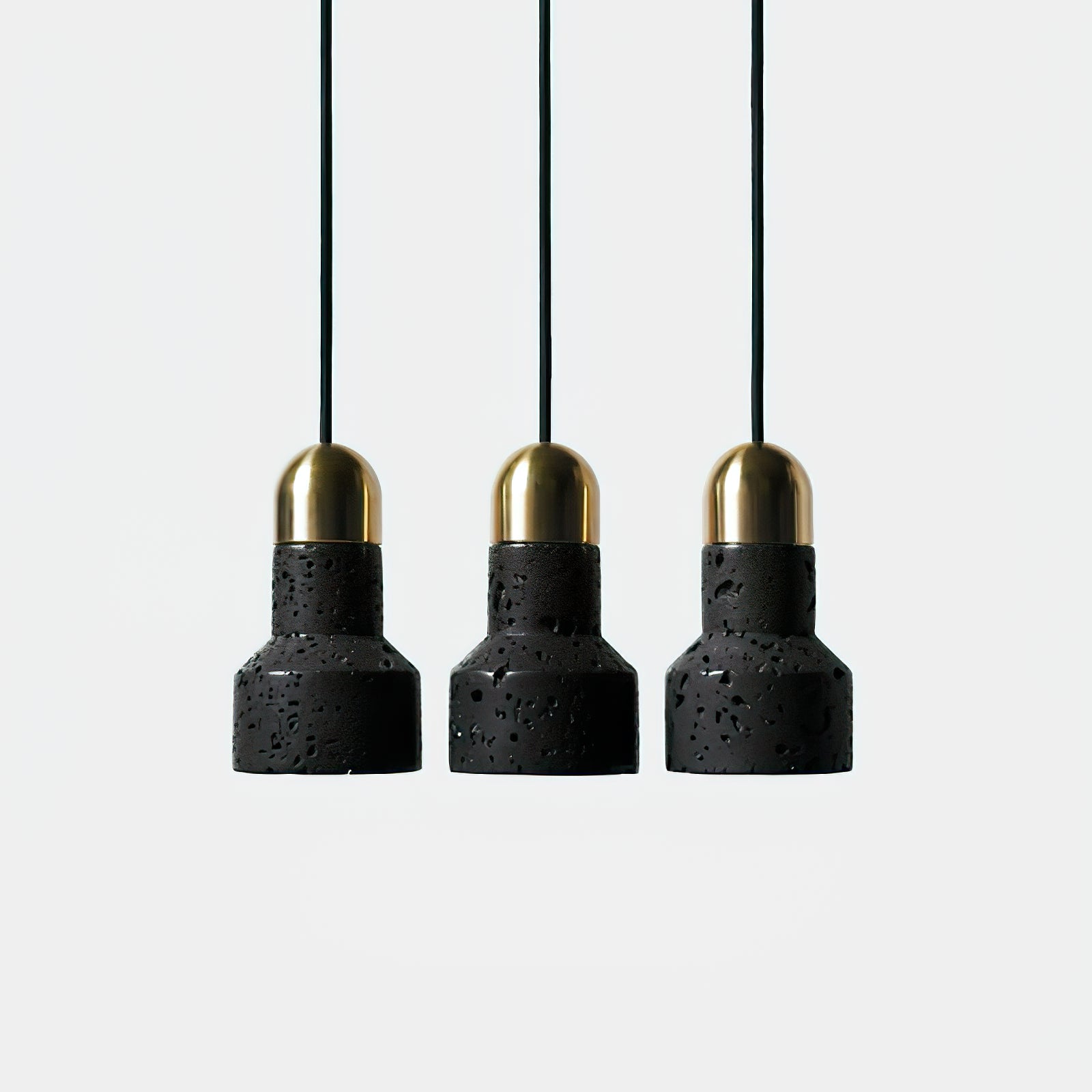 Row of three black stone pendants with gold-coloured tops