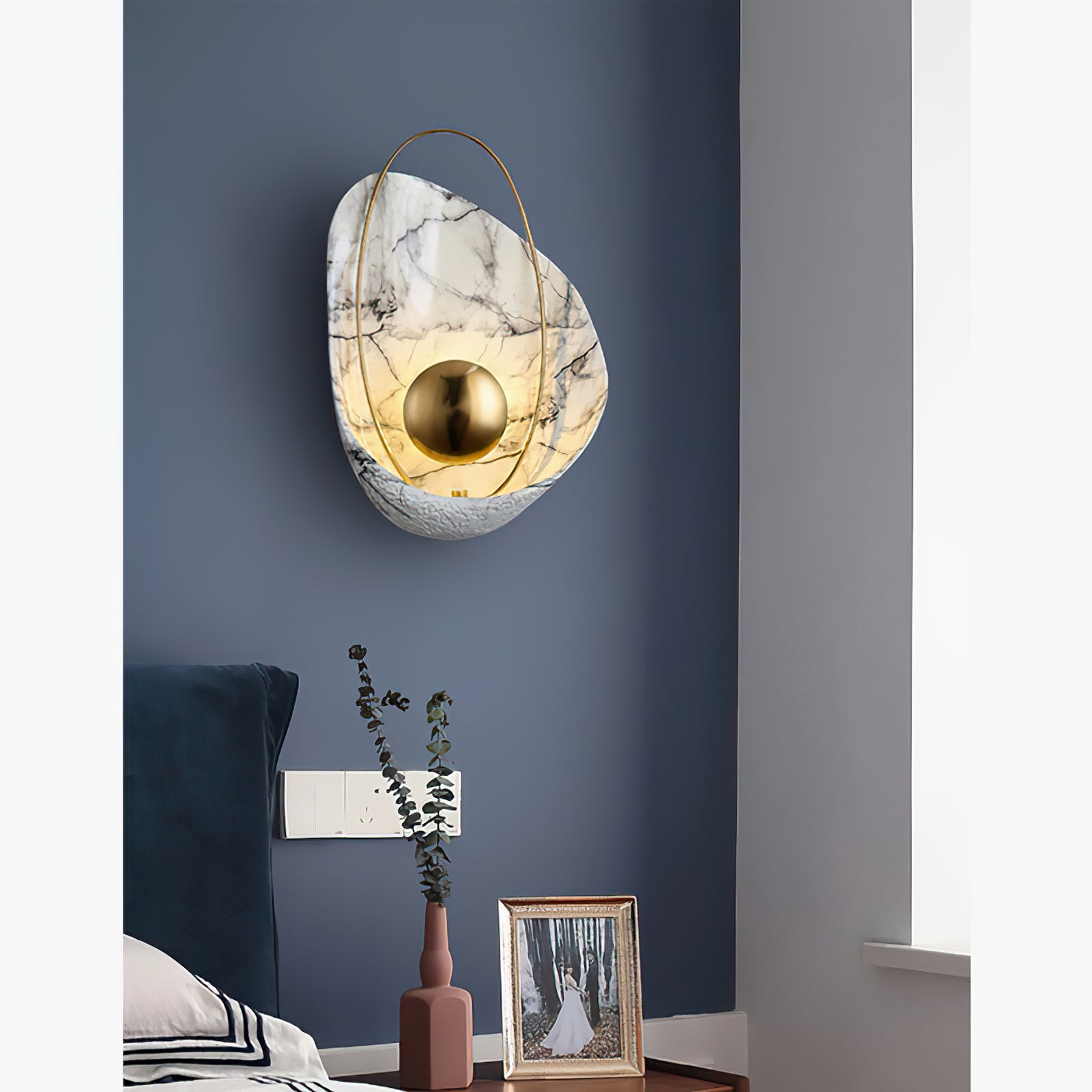 Veined shell wall lamp above a bedside cabinet