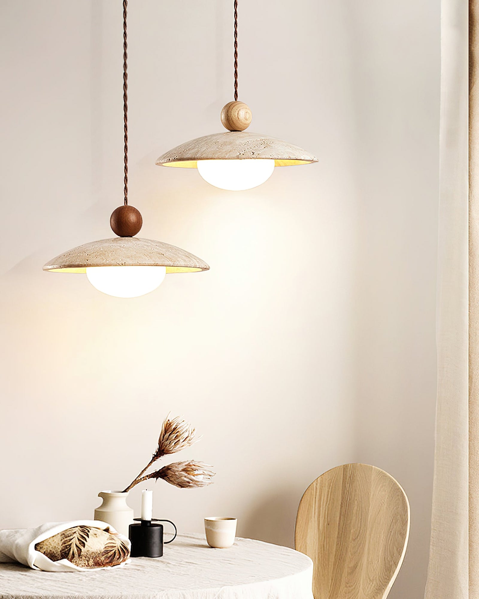 Two stone-disc pendants with different wood tones above a table