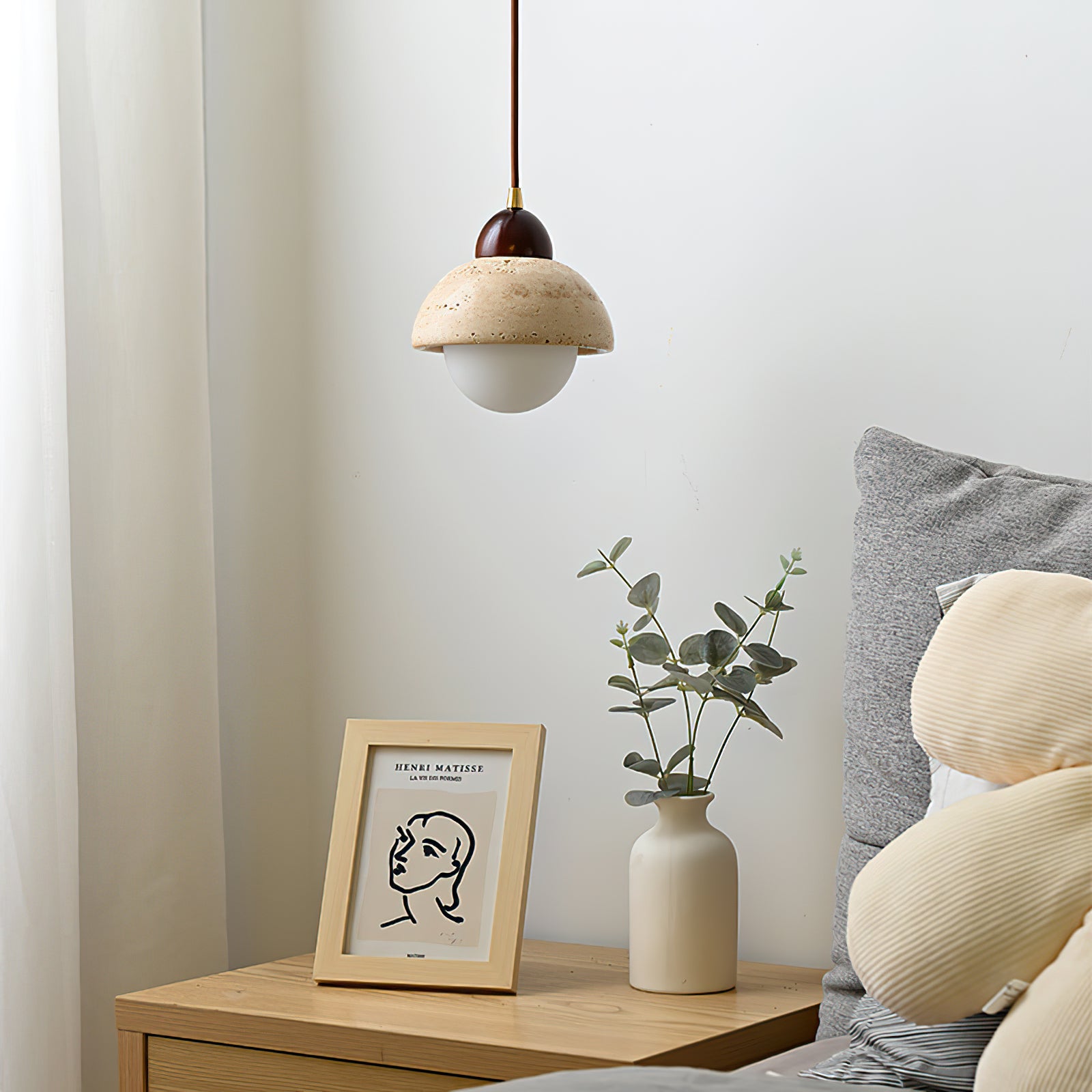 Unlit dome pendant beside a bed with a white lower globe