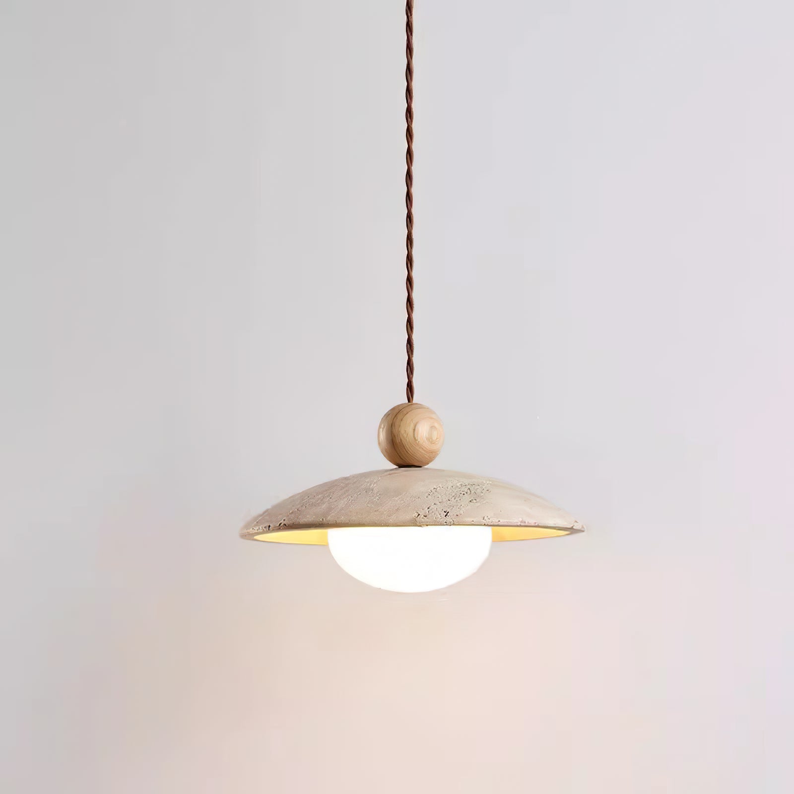 Light tan wooden sphere above a shallow travertine shade