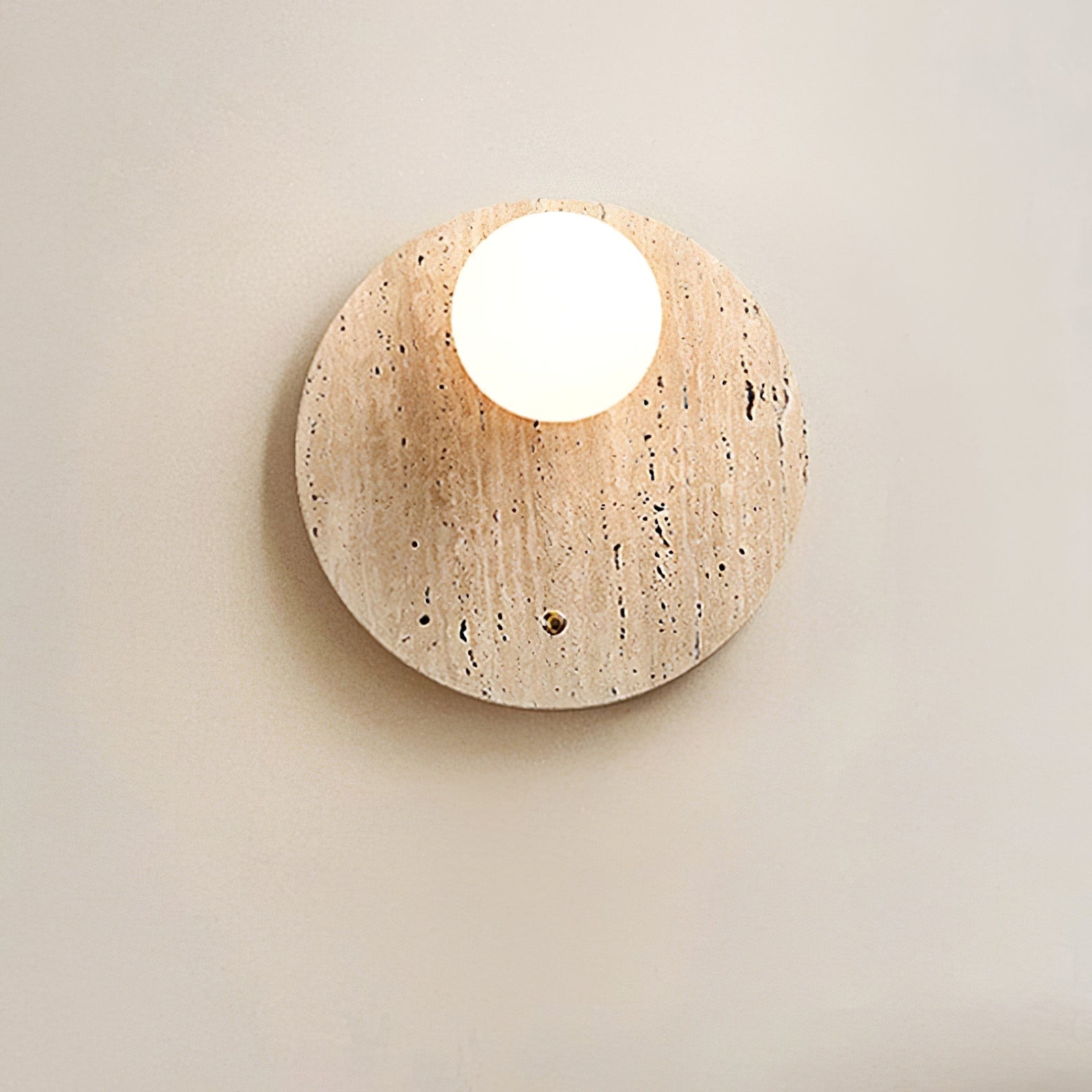 Front view of the illuminated globe on a textured travertine backplate