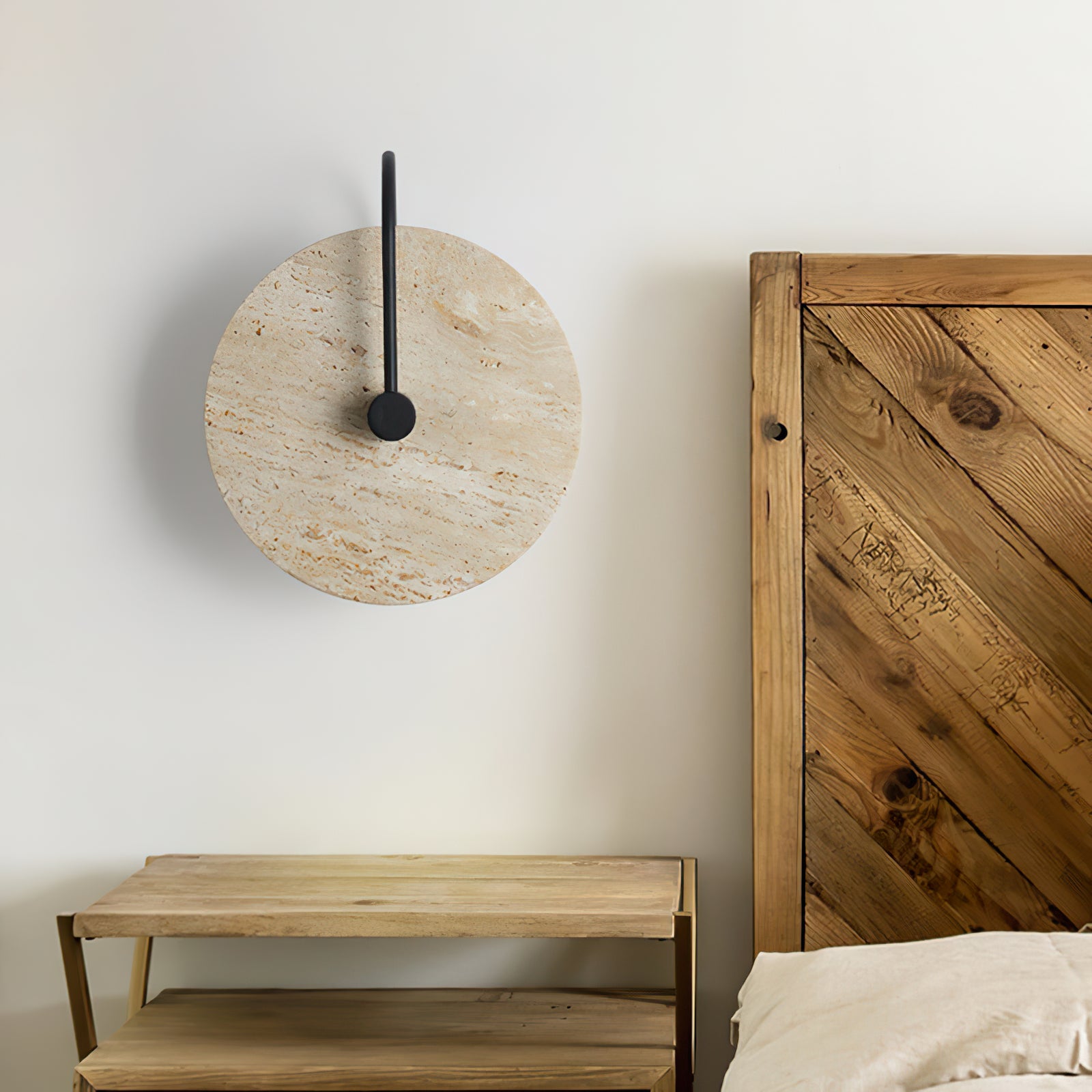 Unlit stone disc wall lamp beside a wooden headboard