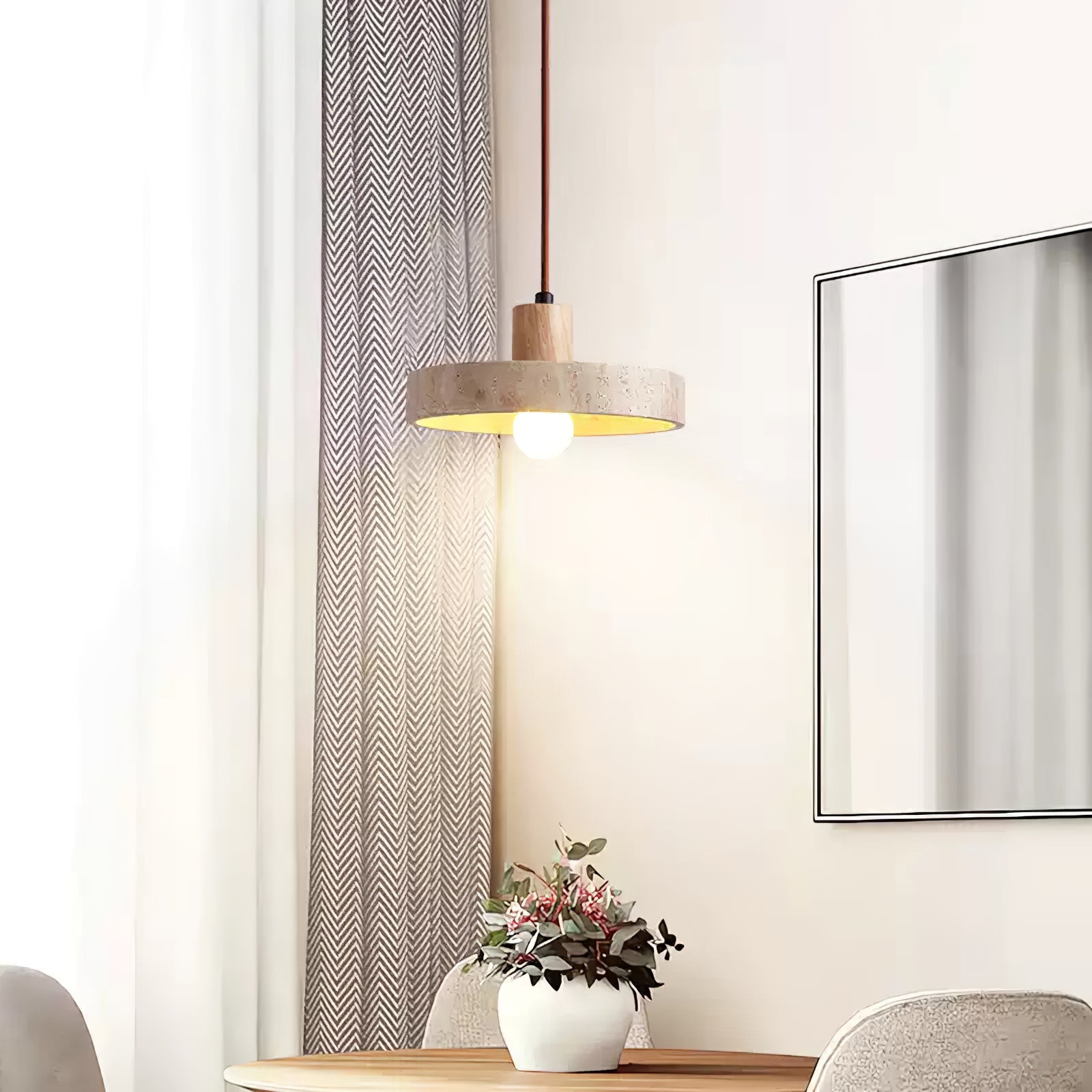 Light wood-stem stone pendant beside curtains and framed art