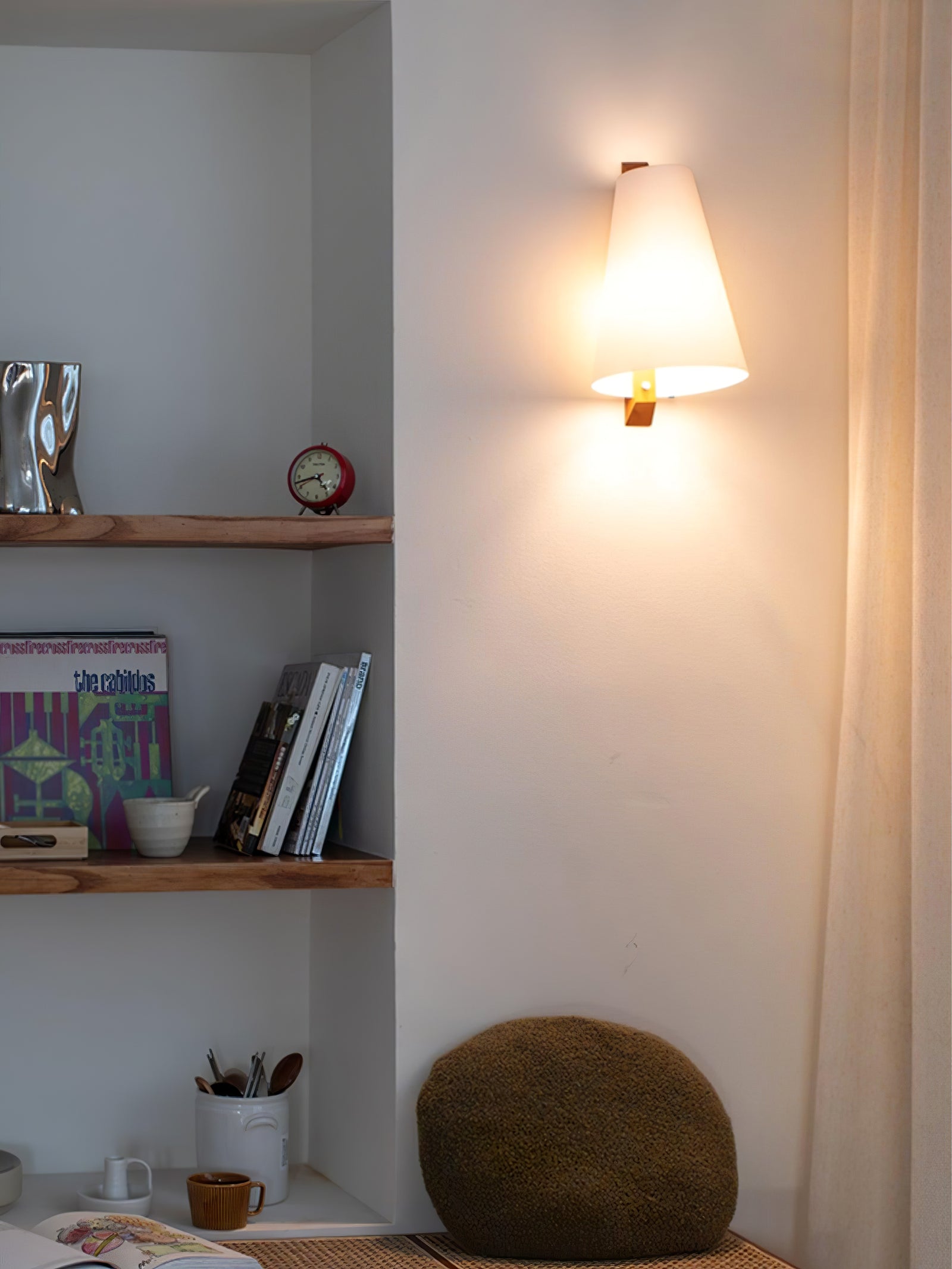 Illuminated Lupe sconce beside shelving