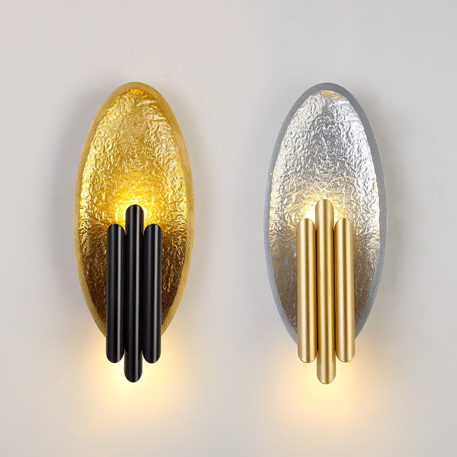 Gold-and-black and silver-and-gold oval wall lights side by side