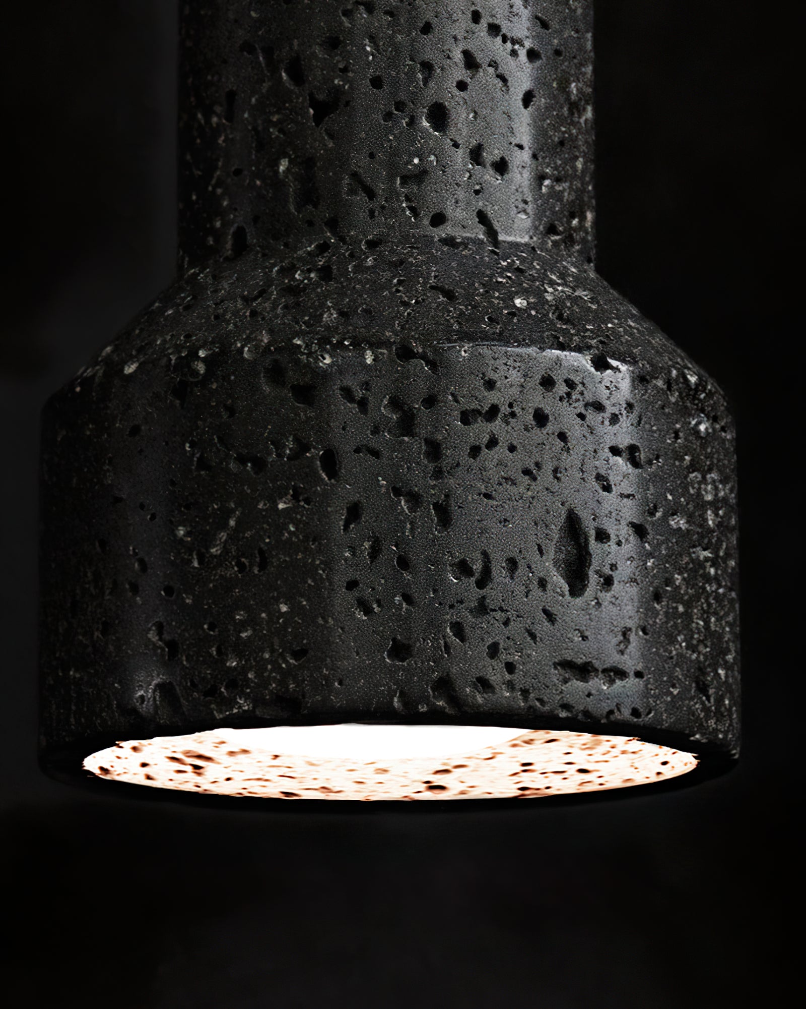 Close-up of porous black shade and illuminated circular opening