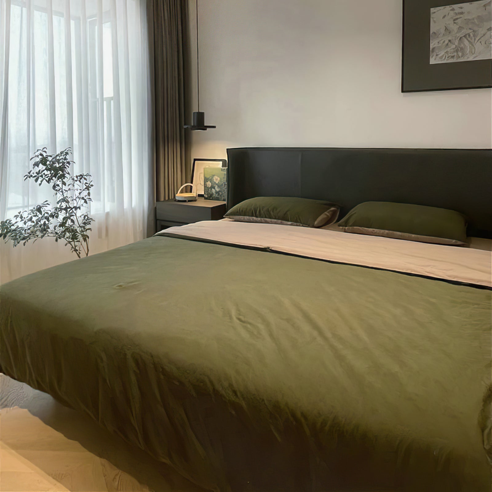 Small black pendant beside a green-covered bed