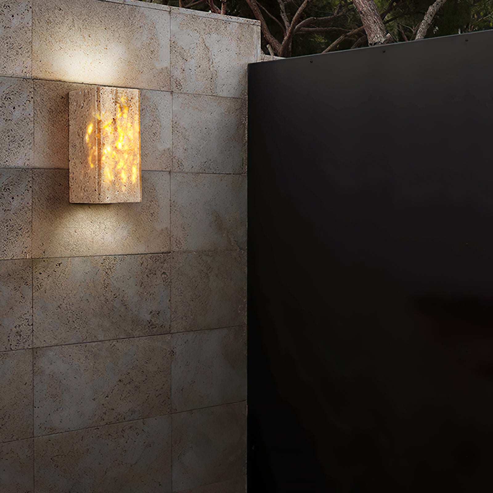 Travertine wall light shown beside a dark entrance door