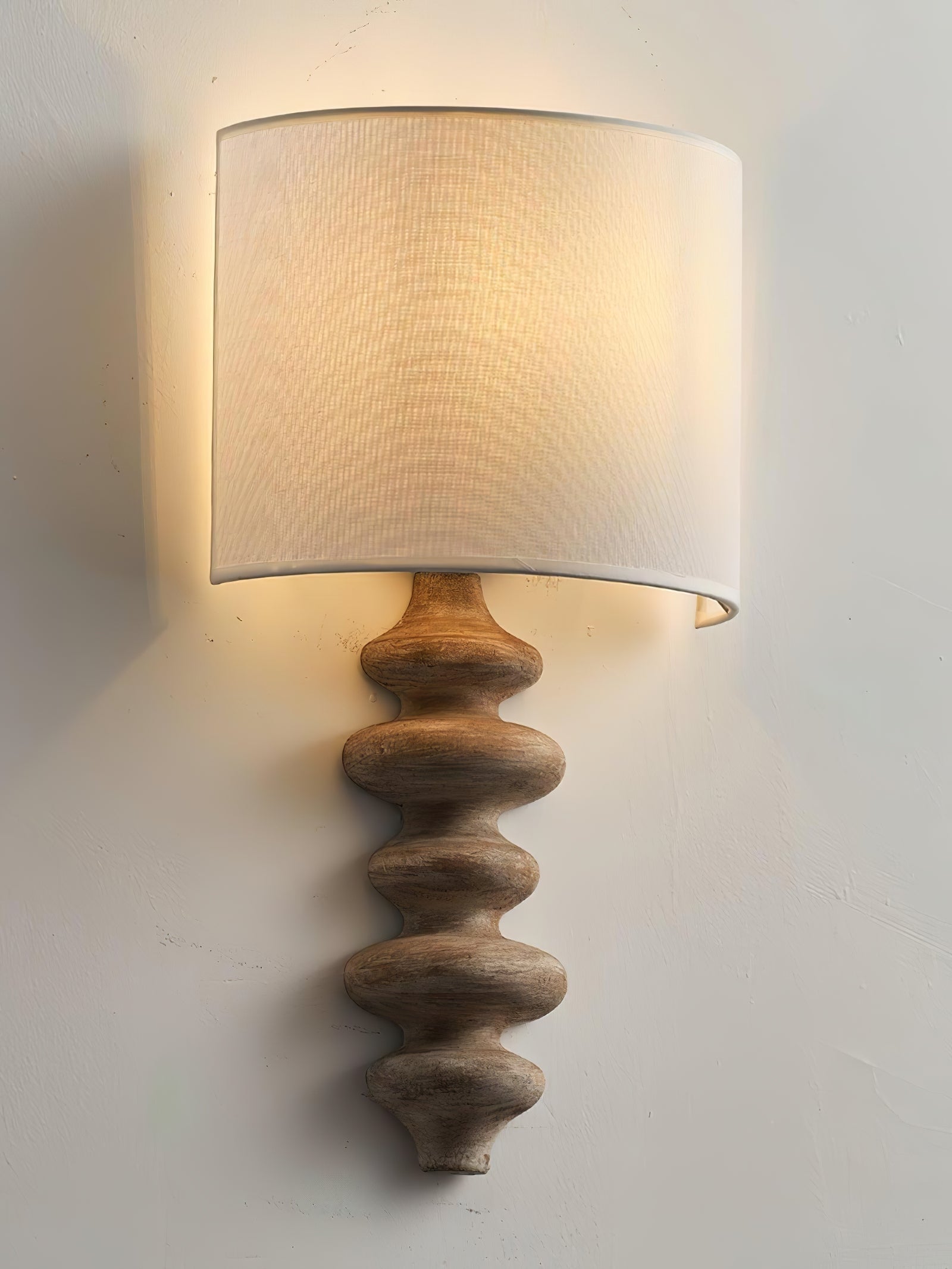 Wood-finish sculptural wall lamp viewed at an angle