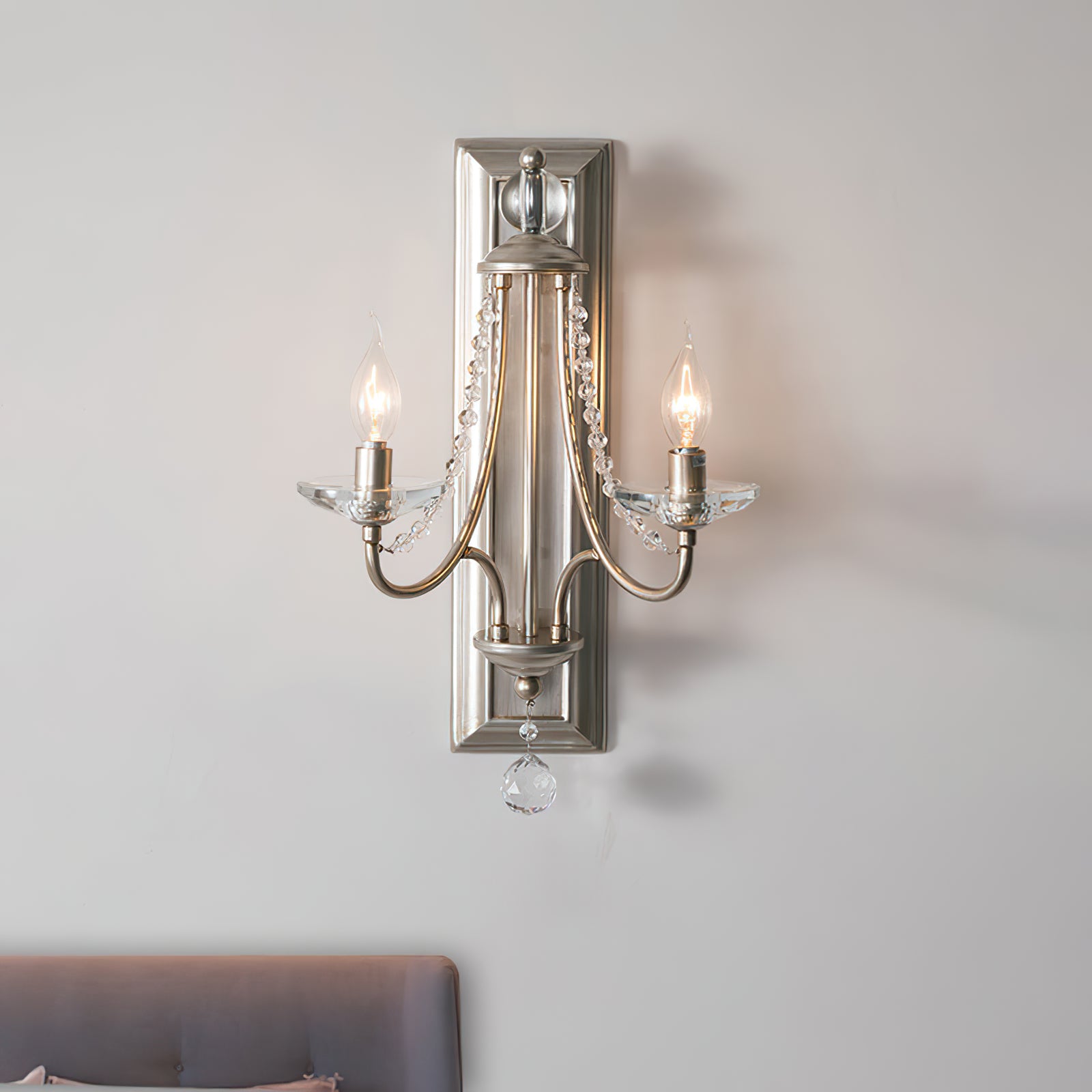 Silver-finish two-arm sconce with a rectangular backplate