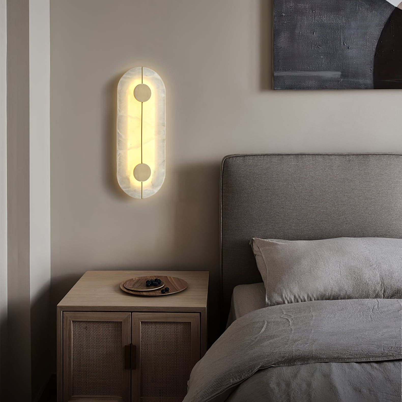 Single oval stone wall lamp beside a bed and wooden nightstand