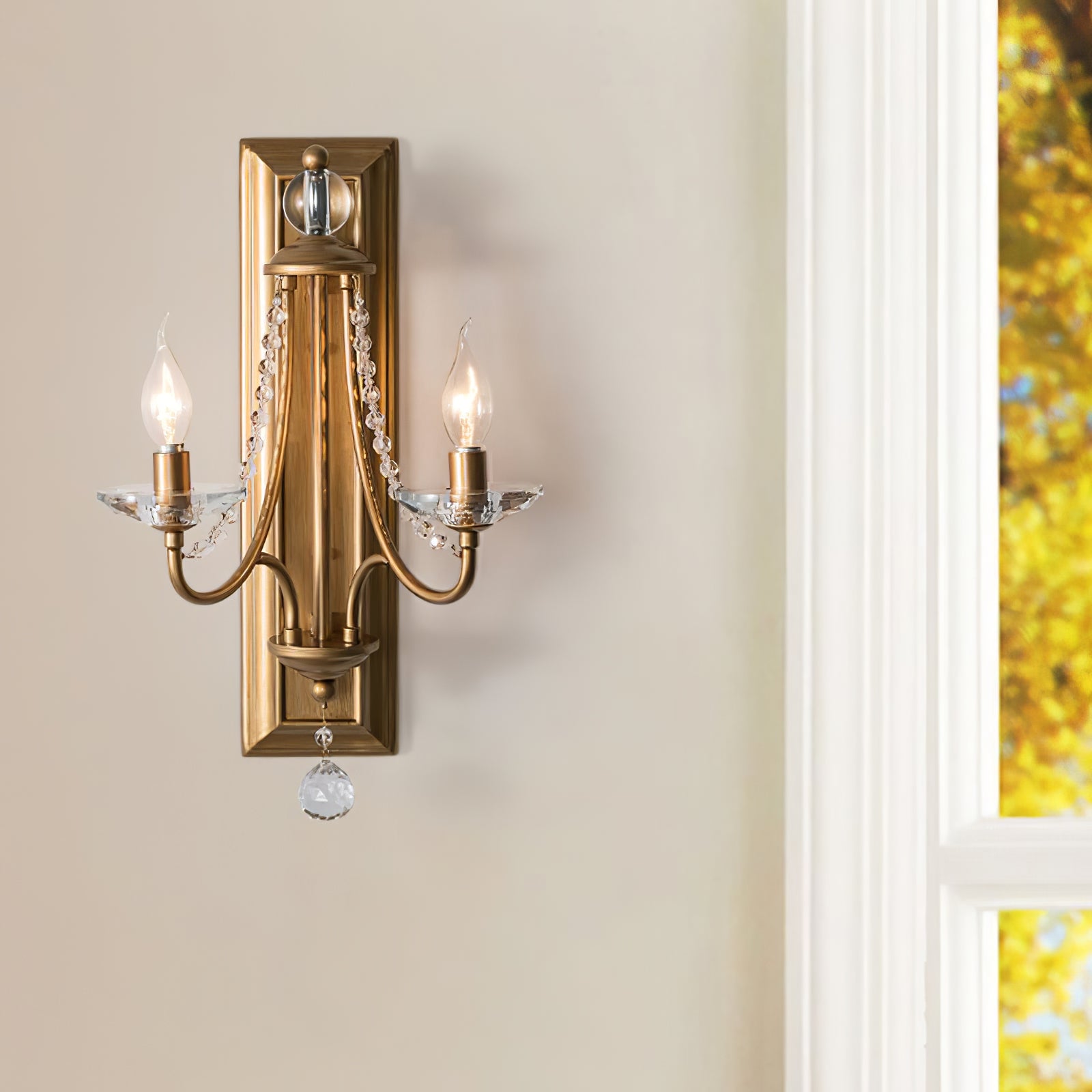 Warm metallic crystal wall lamp beside a bright window