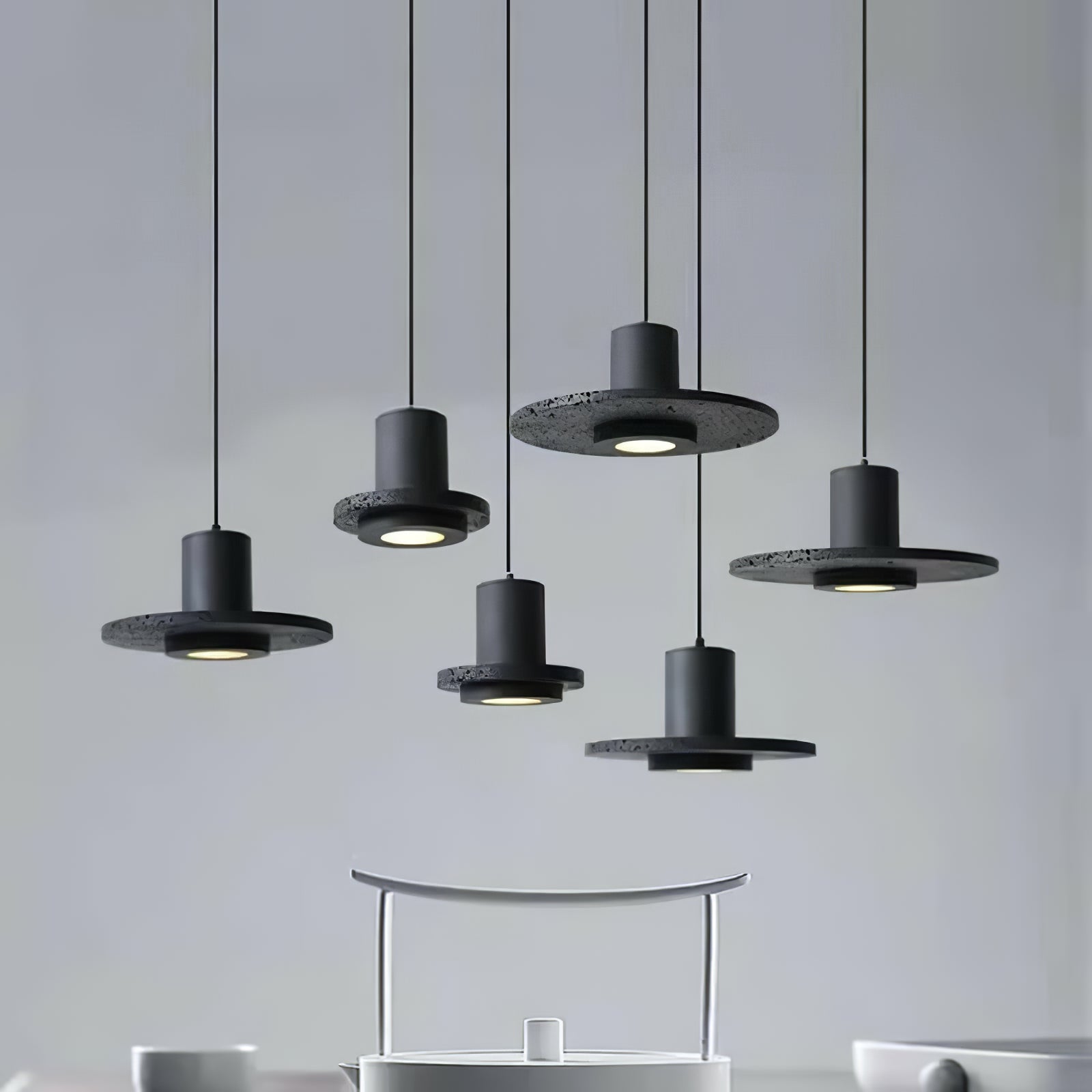 Group of black disc pendants above a pale table