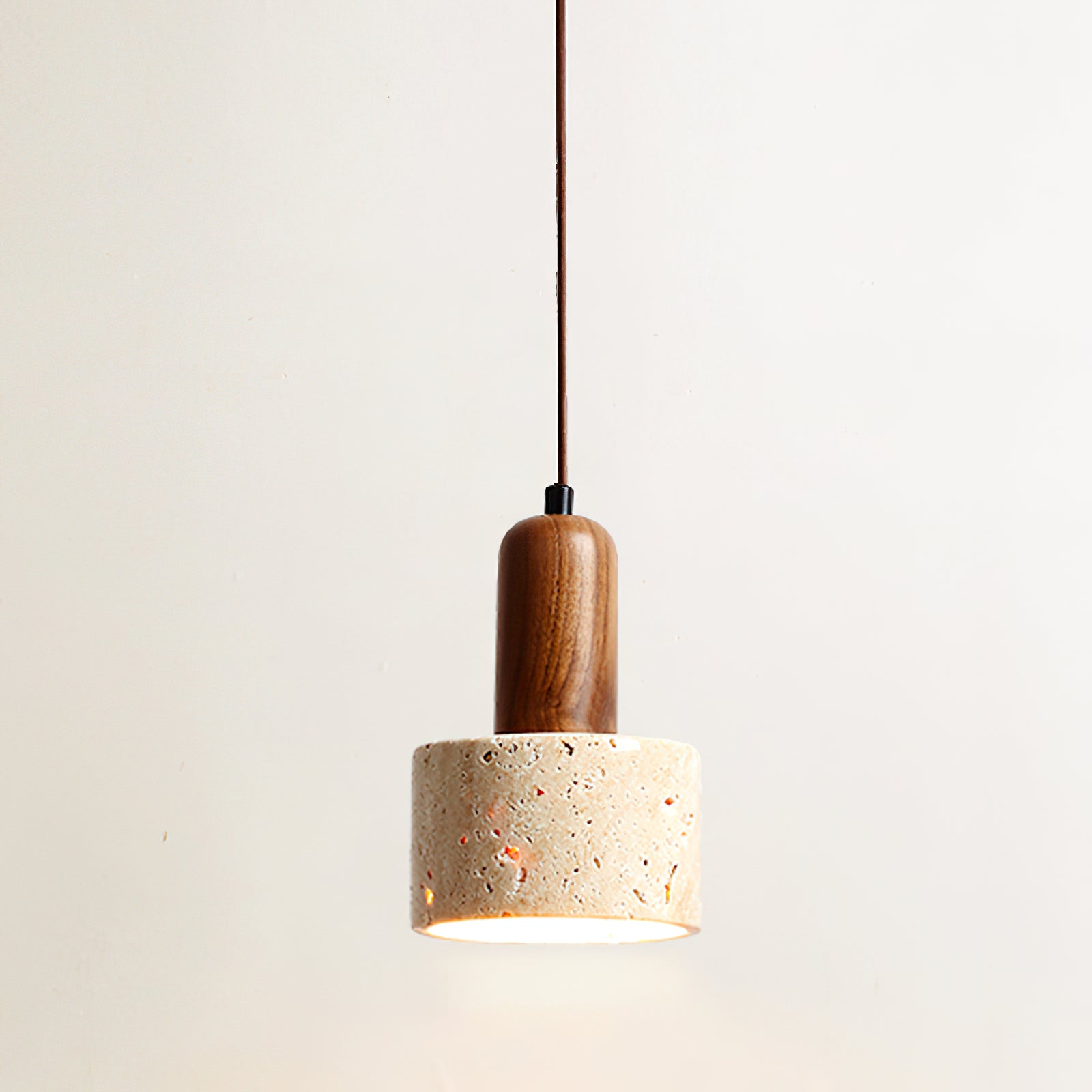 Travertine cylinder with brown rounded stem and lit lower opening