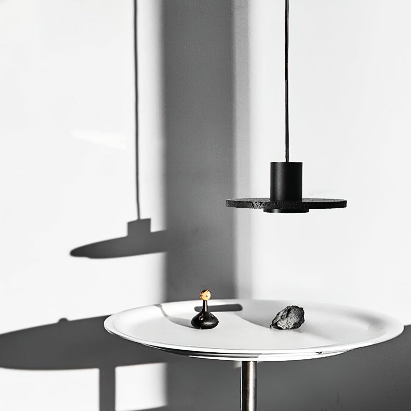 Black stone disc pendant over a small round white table