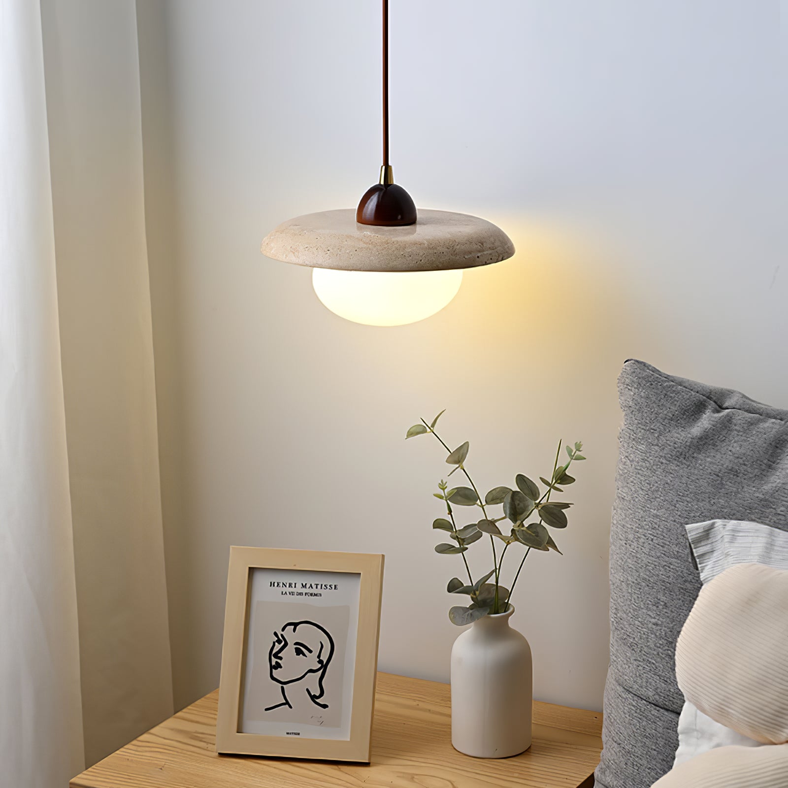Travertine pendant lighting the wall above a bedside table
