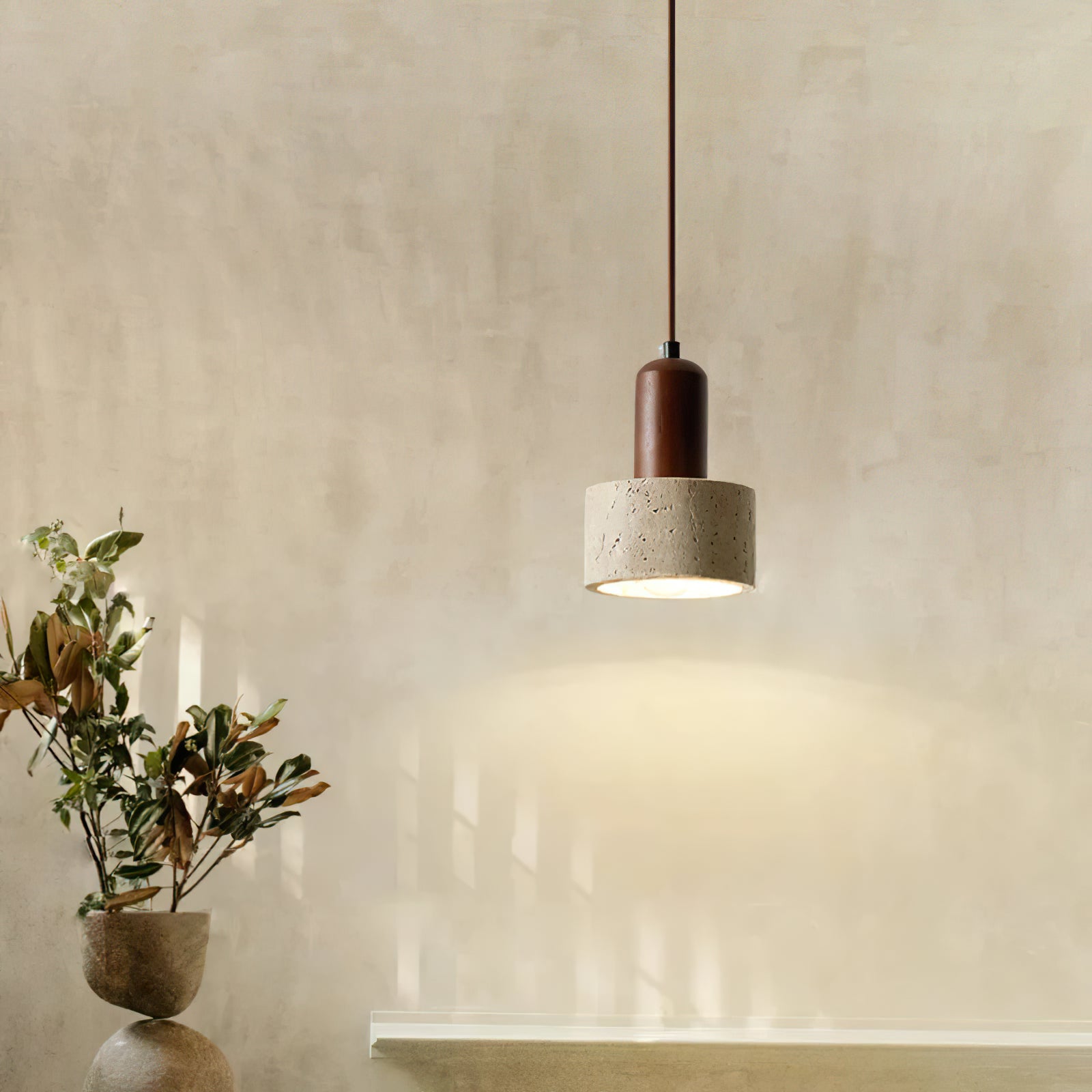 Stone pendant above a cabinet beside branches in a vase