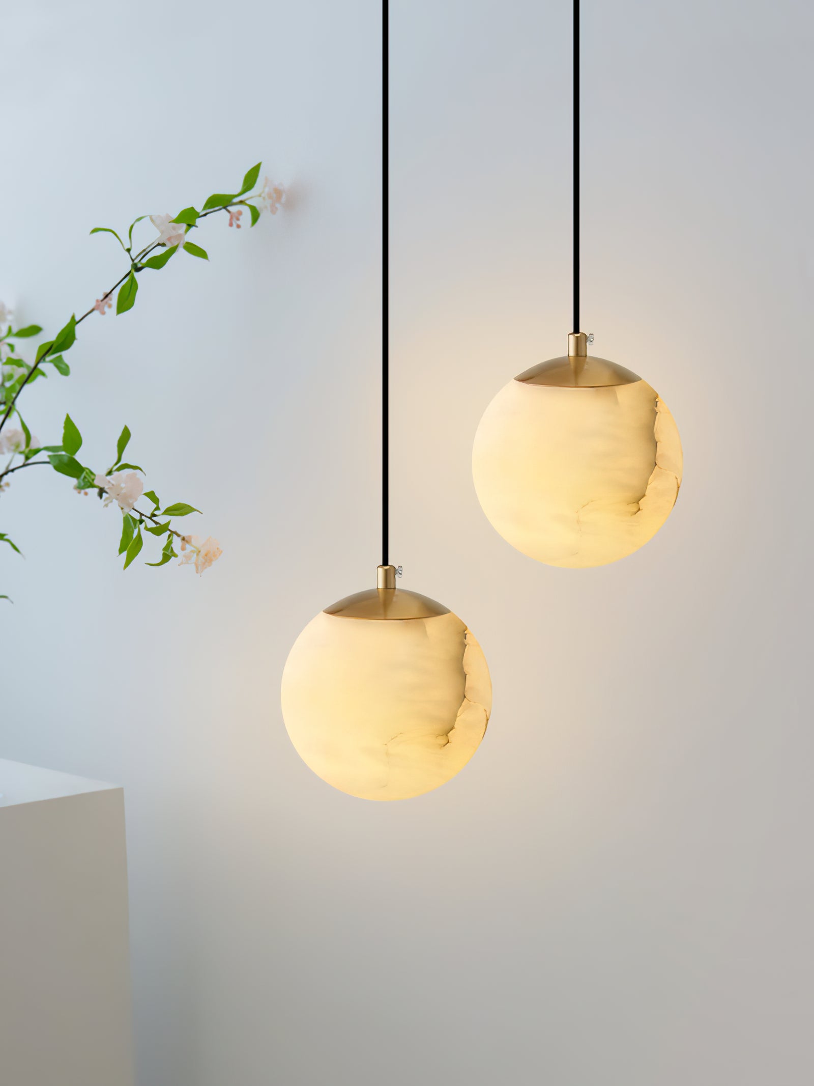 Two veined globe pendants at different heights