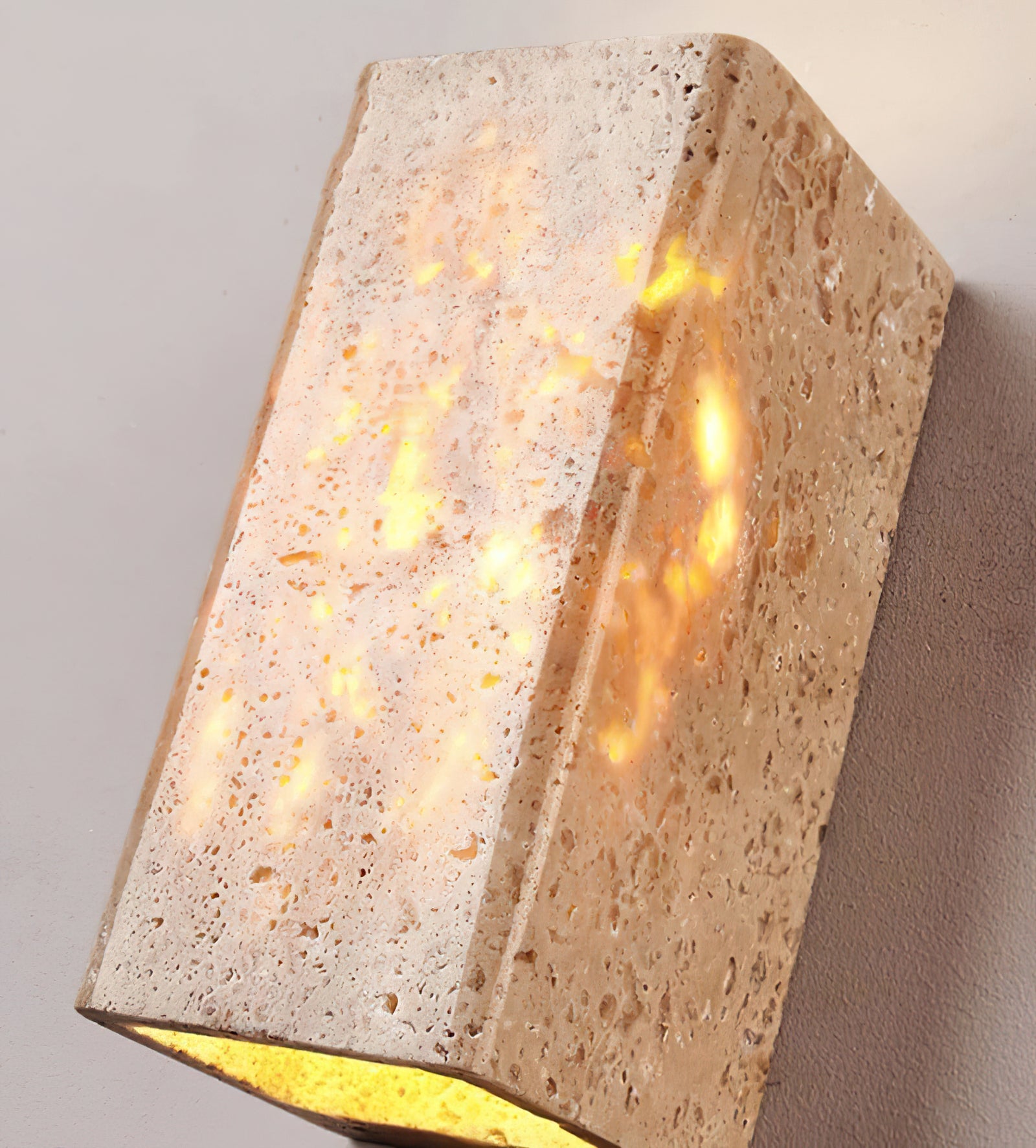 Angled close-up of the travertine shade and illuminated lower opening