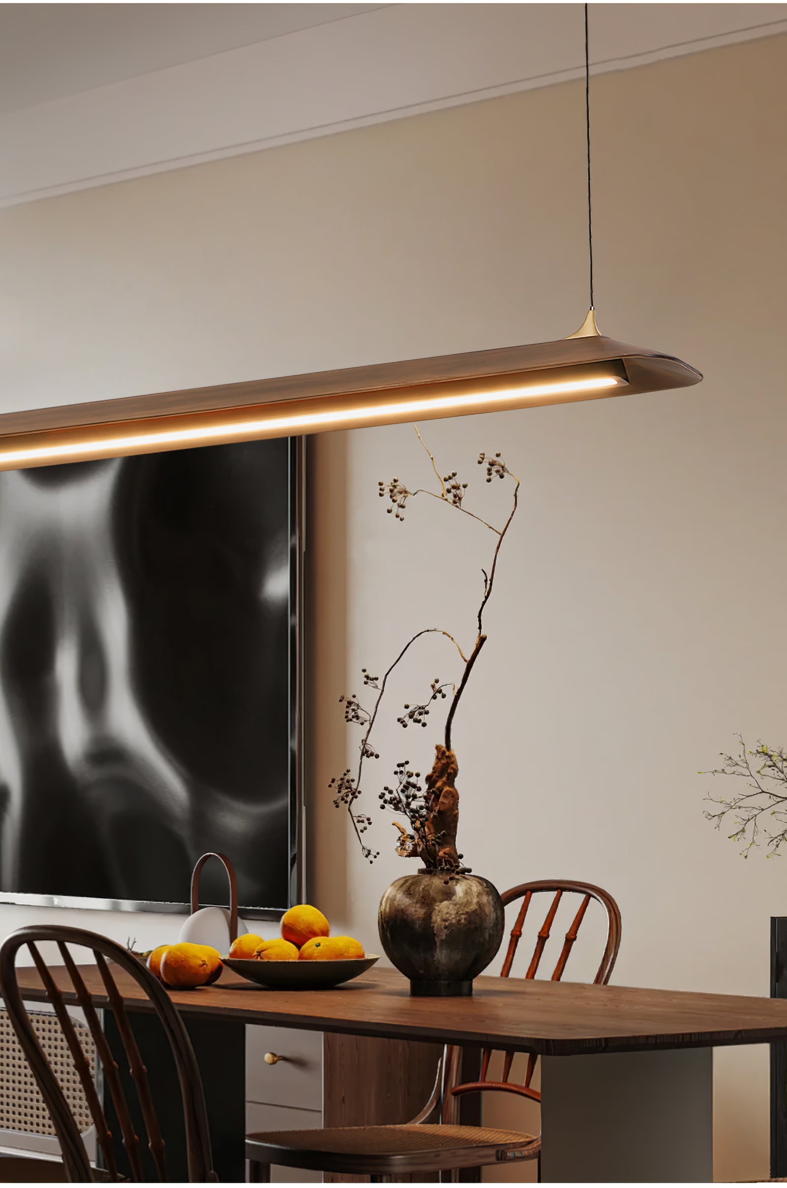 Illuminated underside of a brown pendant over a dining setting