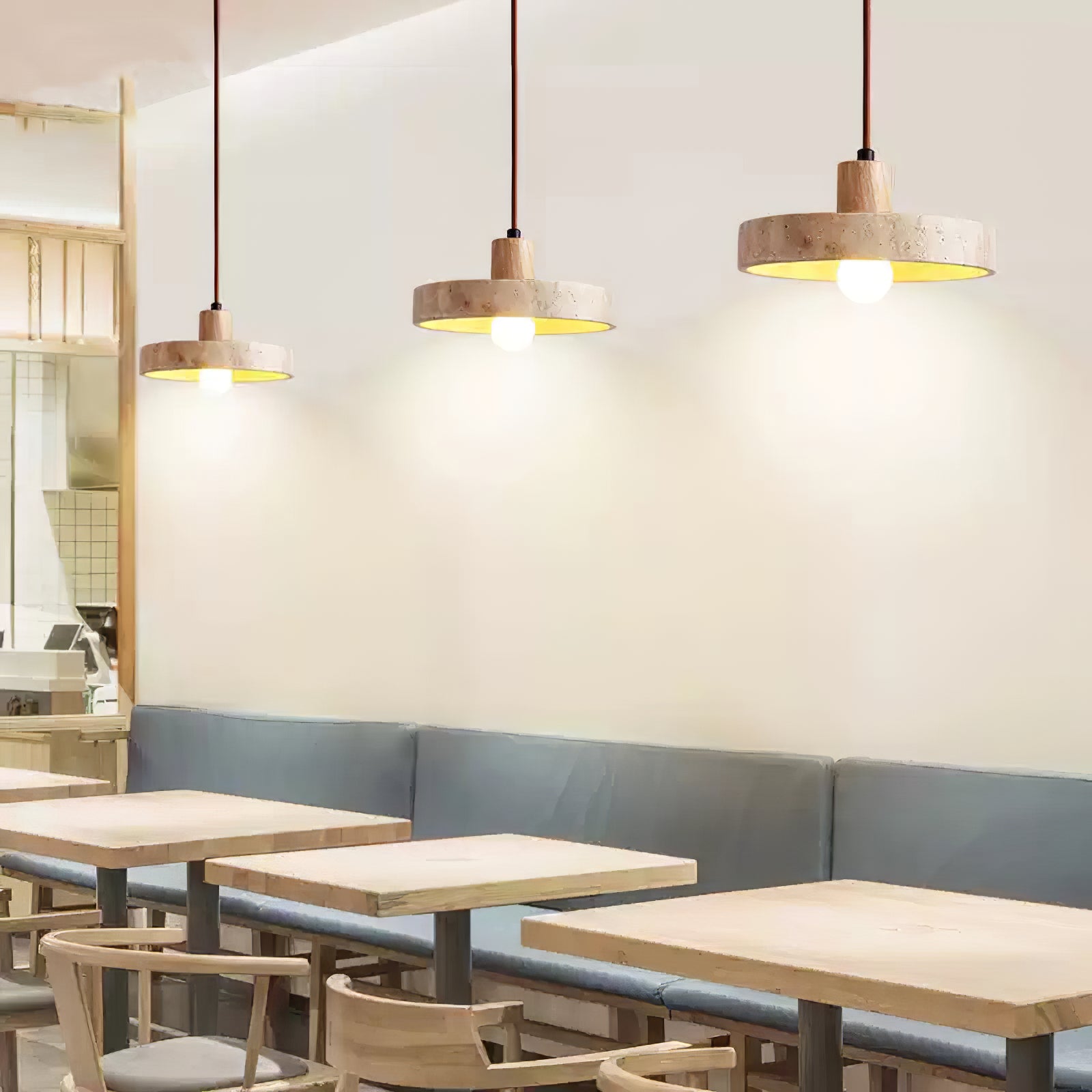 Three small travertine pendants above cafe tables