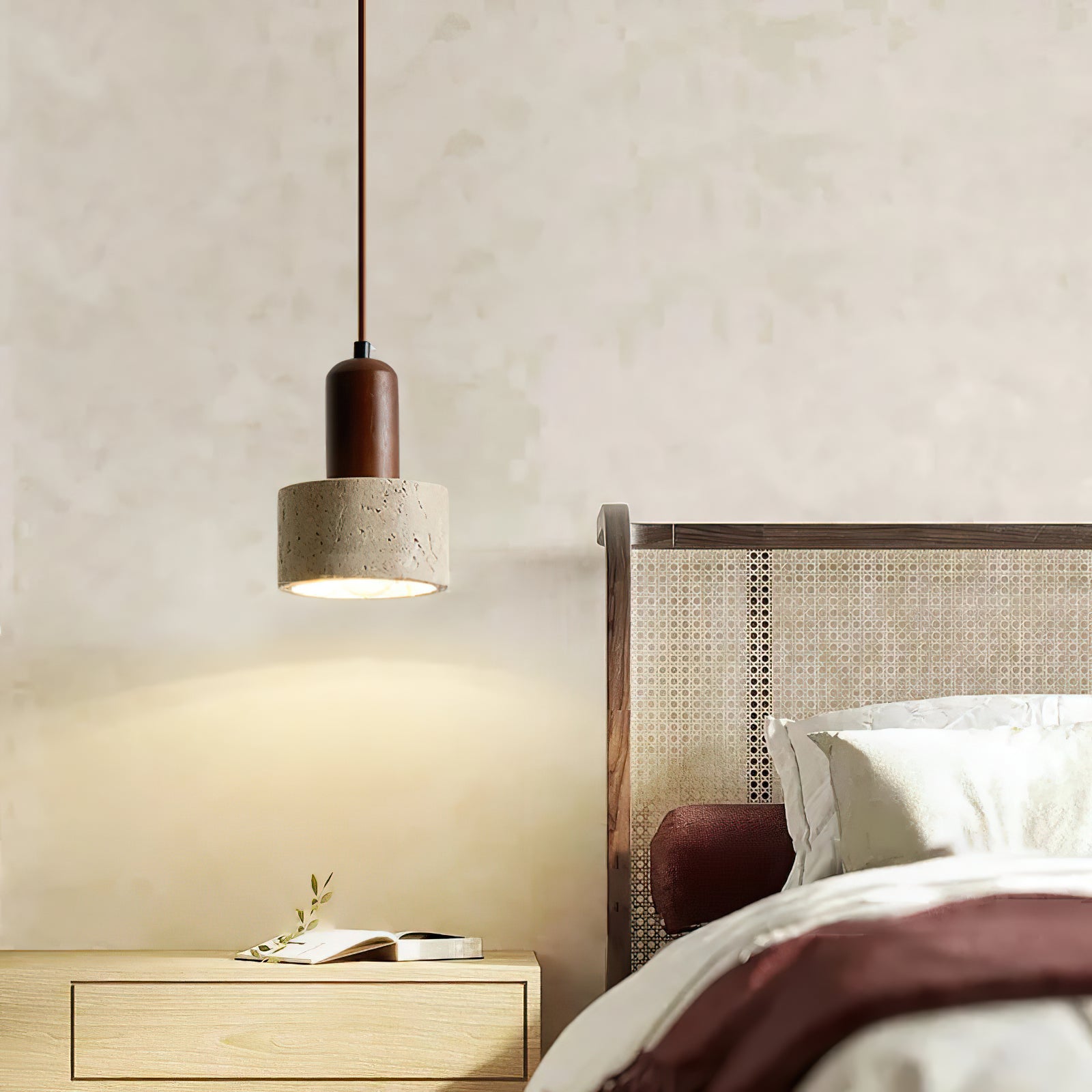 Travertine pendant beside a woven headboard and wooden nightstand