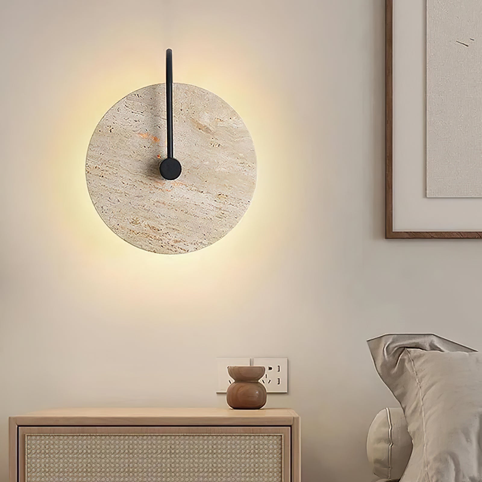 Travertine disc and black arm above a wooden cabinet