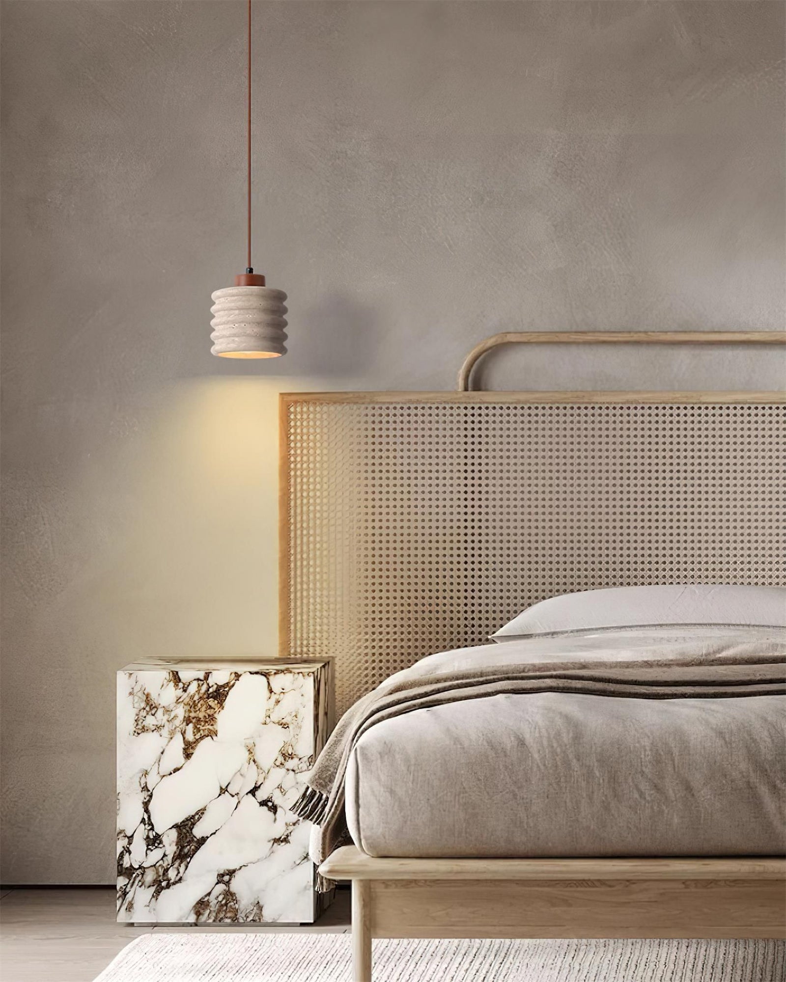 Small travertine pendant beside a woven headboard