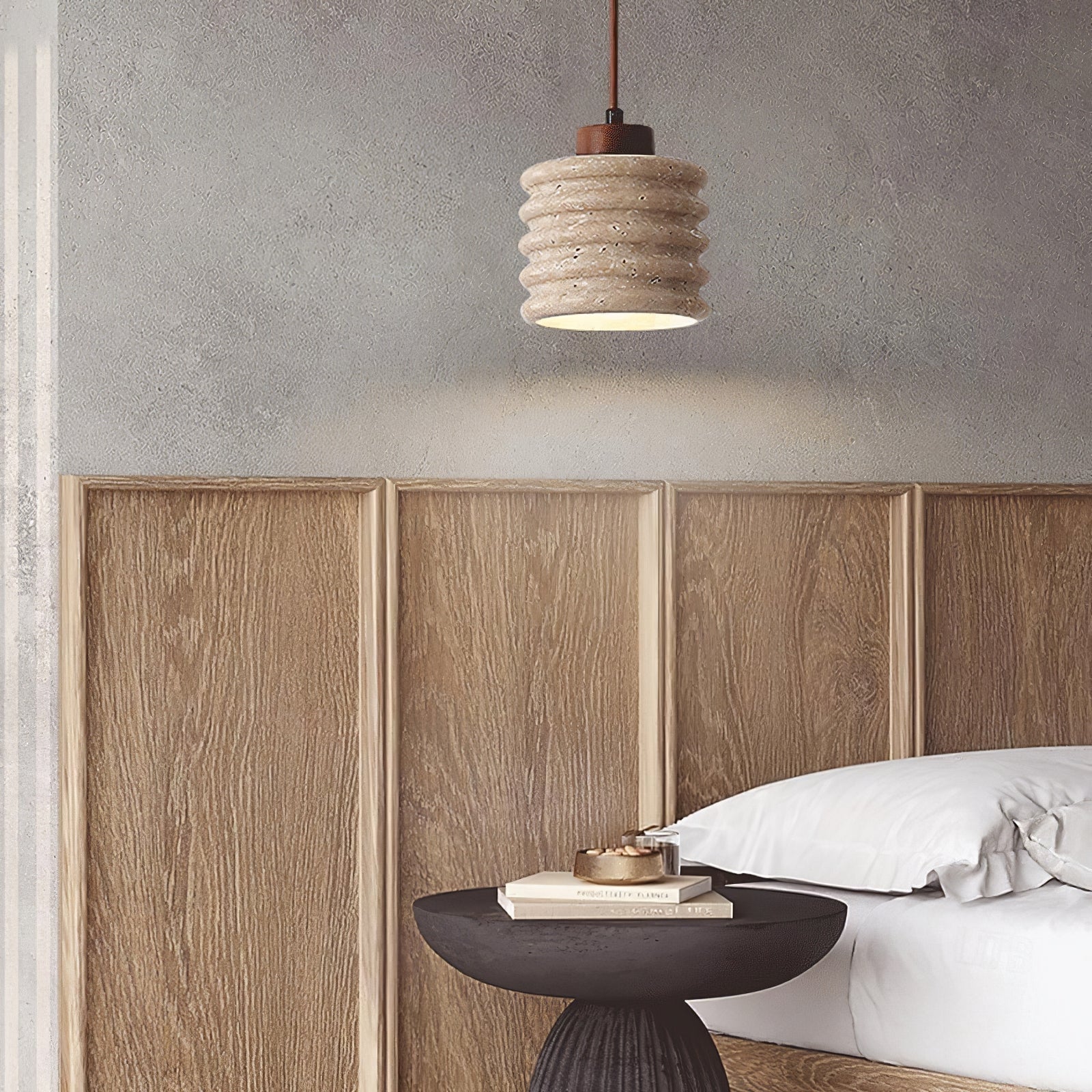 Ribbed cylinder pendant above a bedside table and wood headboard