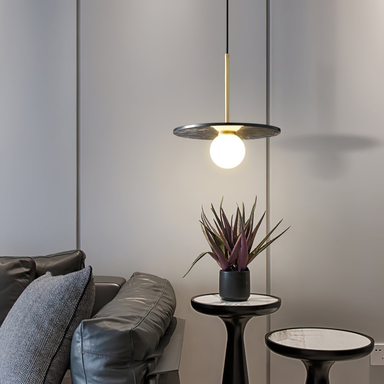 Green marble disc pendant beside a sofa and plant