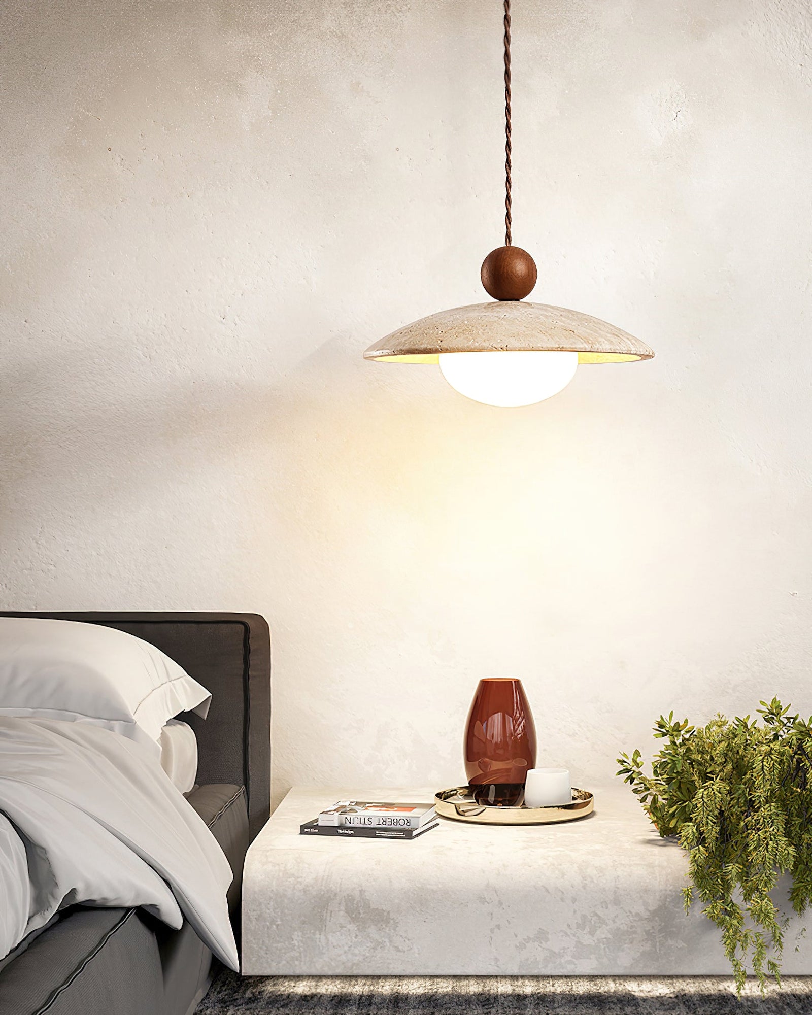 Lit dark wood-sphere pendant above a bedside table
