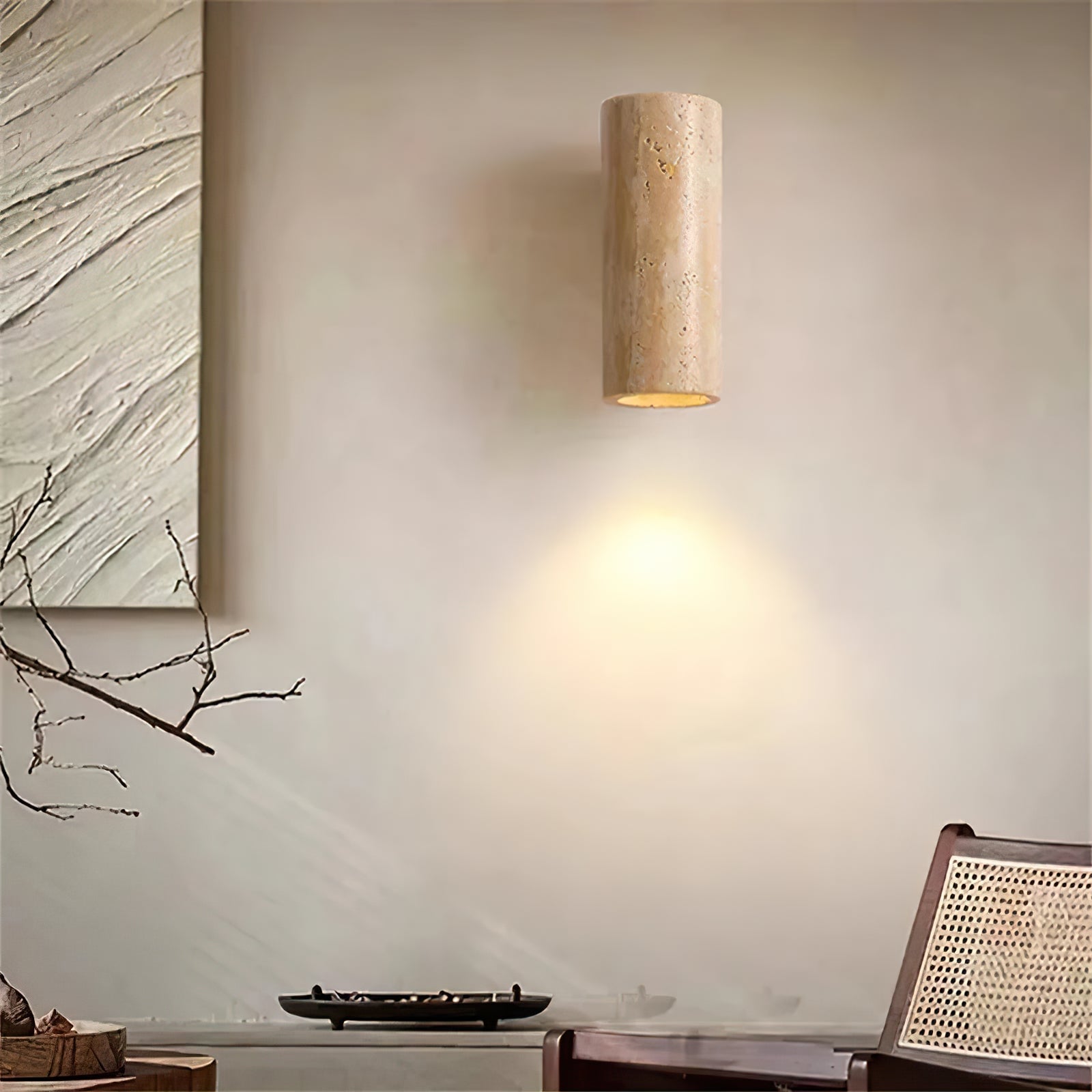 Illuminated travertine wall lamp above a console and chair