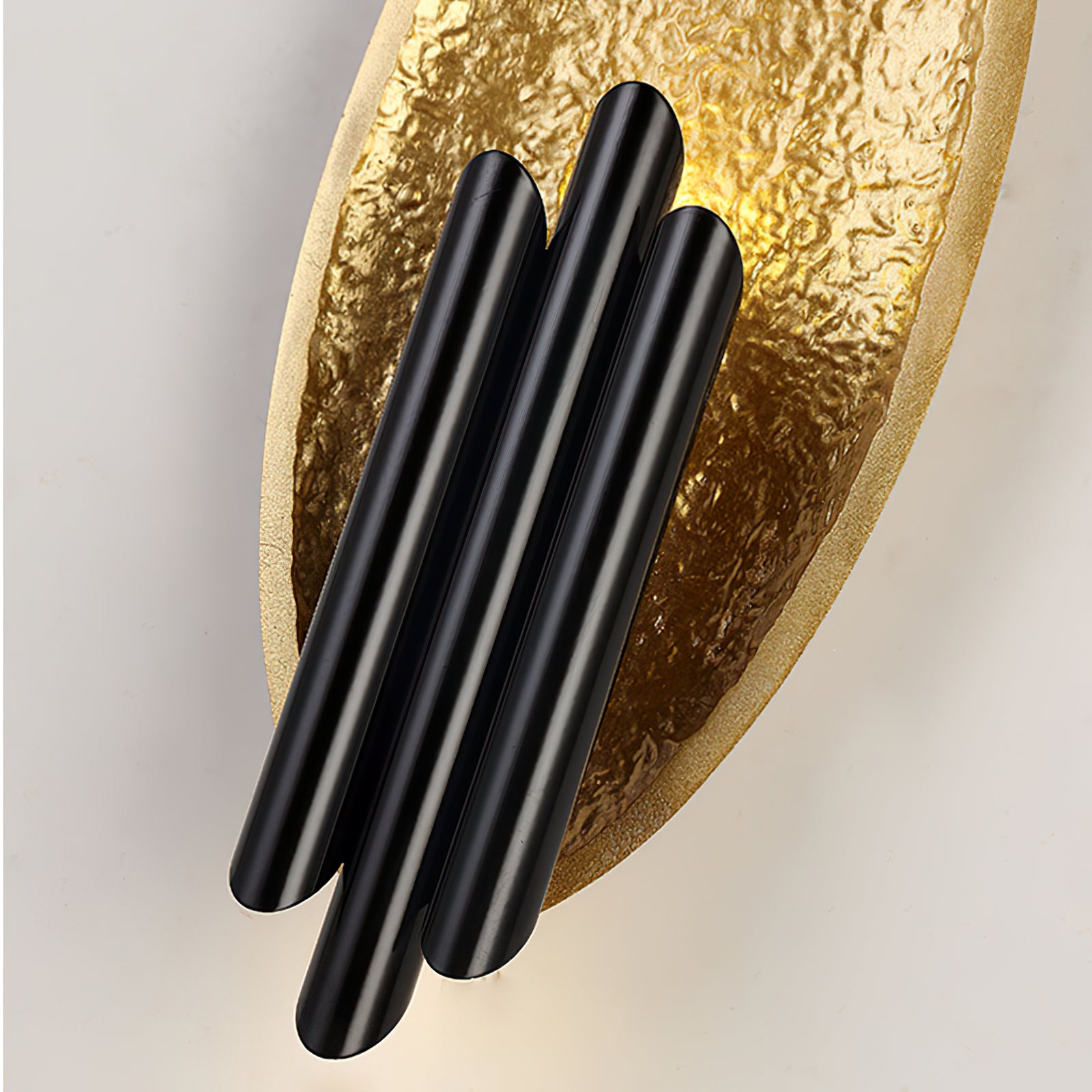 Close-up of smooth black bars against textured gold backing